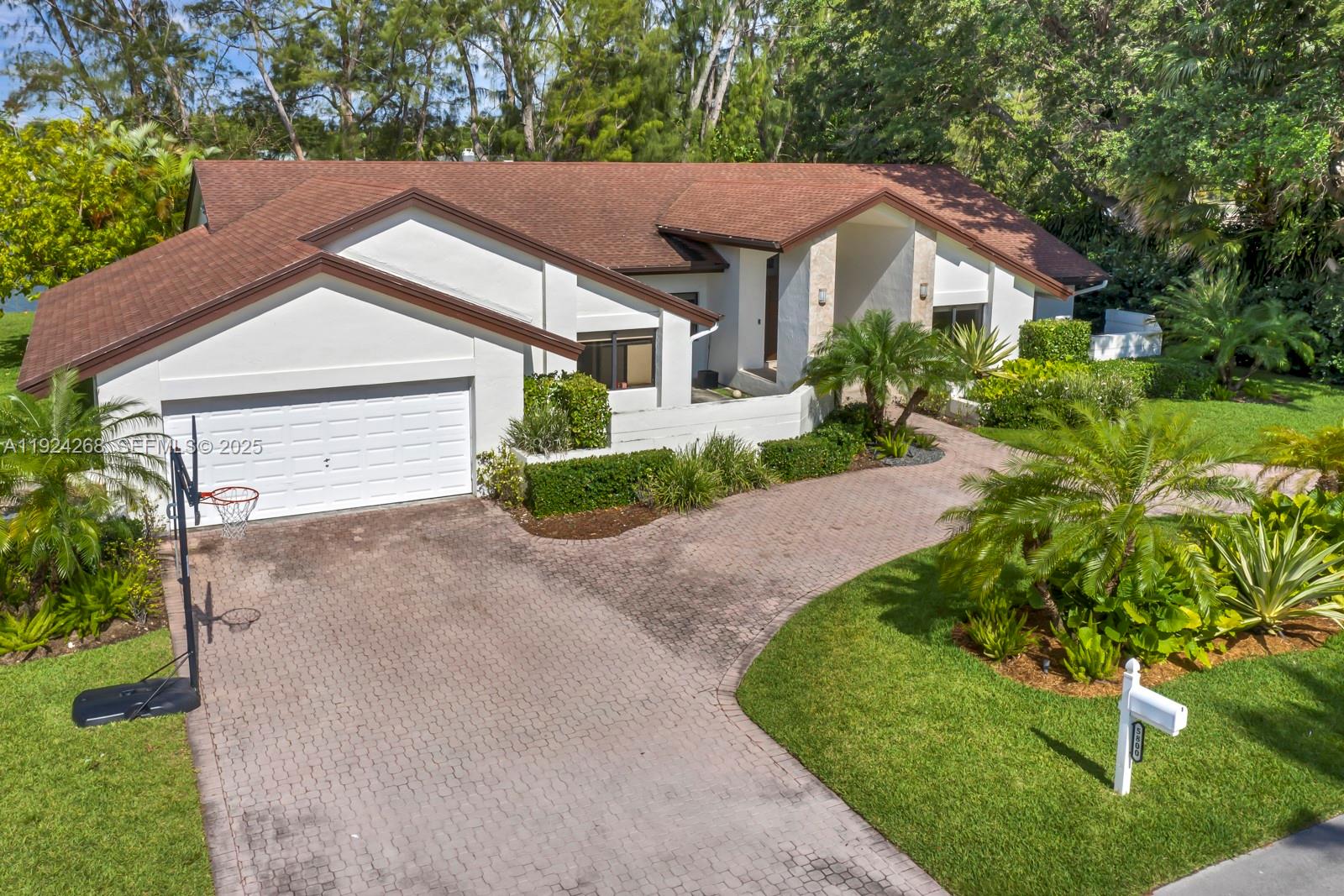Nestled in central Miami, this exquisite 5-bed, 4-bath residence sits by a tranquil lake, with easy access to highways, shopping, and dining. Welcomed by a graceful foyer, guests are led to an expansive living room and rear terrace, blending indoor-outdoor living. The left wing features a well-appointed kitchen, spacious living/dining area, formal dining space, and a bedroom with an on-suite bathroom. The right wing boasts 4 bedrooms and 3 bathrooms, ensuring ample accommodation. Natural light bathes the home, creating warmth through the hurricane impact windows. A 2-car garage and circular driveway offer convenience and ample parking.