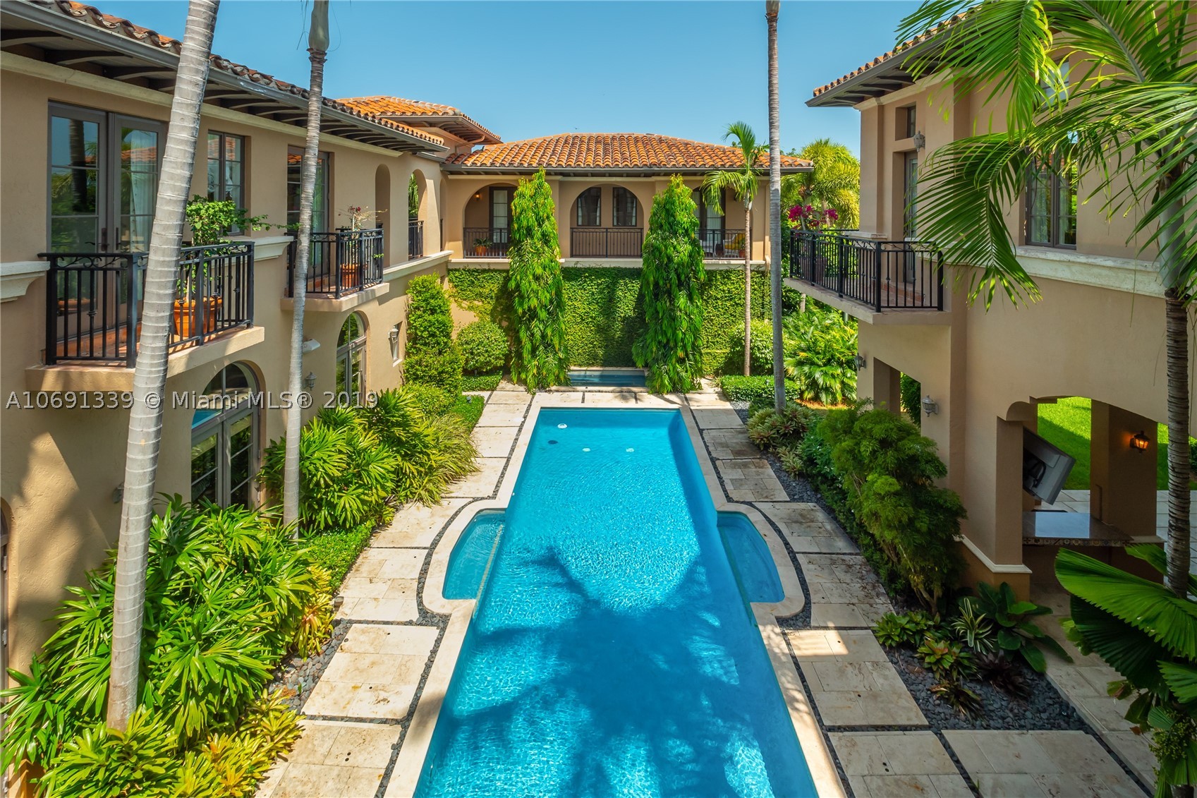 Rare offering of an exquisite custom estate set on a corner 20,500 sq.ft lot with 10 foot elevation and tucked behind mature hedges. Sprawling 7,698 sq.ft. (per plans) of living areas set among carefully conceived garden rooms with tropical landscape views from every window. Formal entrance leads to 12 ft ceilings with detailed moldings. This 7 bed and 8 ½ bath residence has thoughtfully designed living spaces. Expansive windows flood home with natural light. Features include private gardens, pool,separate 2 bed guest house, chef's kitchen with butler pantry & wine room cooled to exact temperature. Staff quarters with bath next to laundry room. Home’s occupants will enjoy 2 family rooms, one up one down, pool spa, 3 car garage, covered patio with built in grill and wet bar. Sheer elegance!