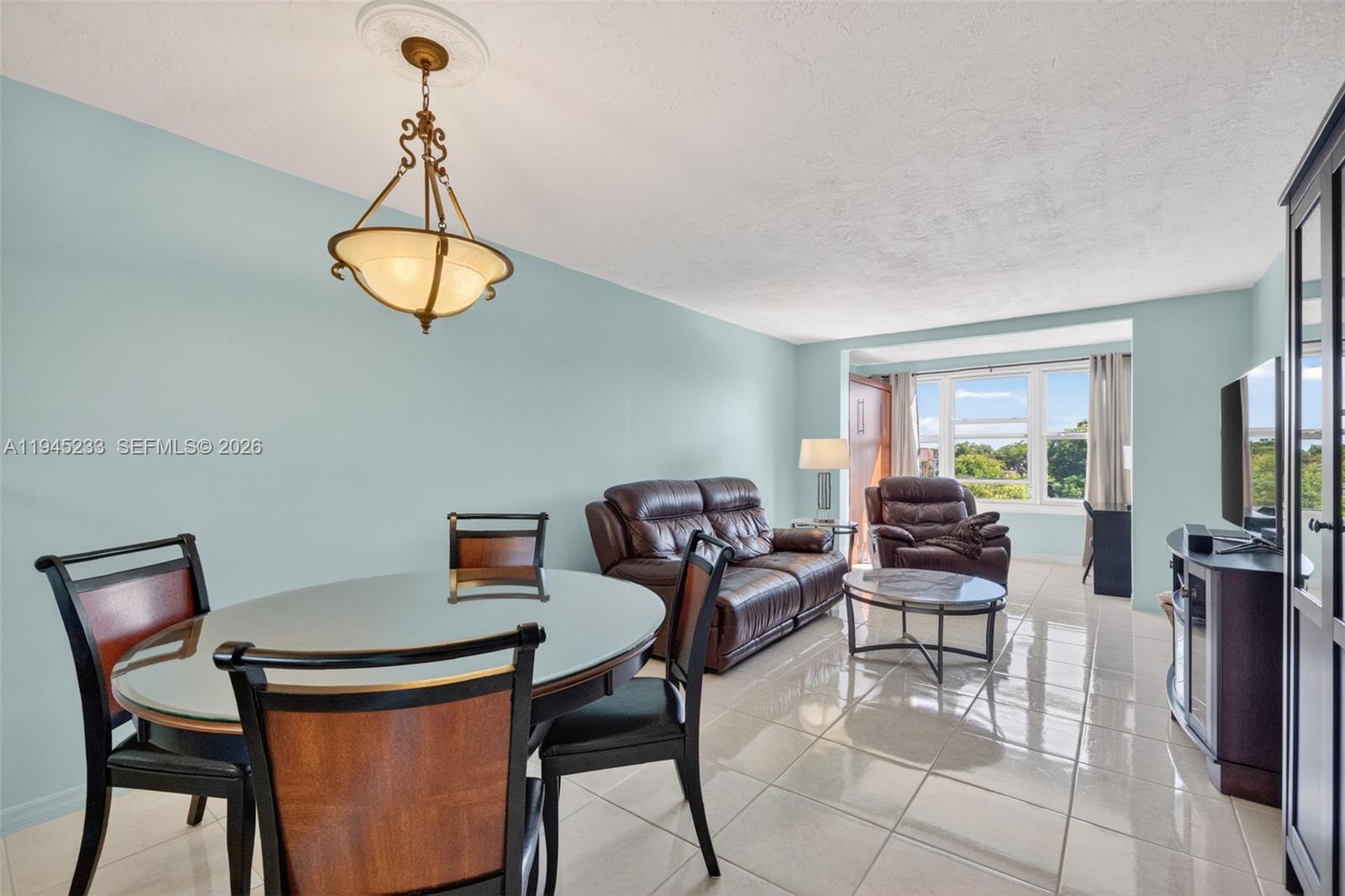 Gorgeous and absolutely completely remodeled corner unit with 1 bedroom and 1 bathroom. Offered fully furnished and turnkey. From the moment you enter, you’ll be impressed by the gleaming porcelain tile floors and the abundance of natural light from numerous windows—all impact-resistant—creating a bright and inviting atmosphere. The beautifully updated kitchen features rich wood cabinetry, granite countertops, and stainless steel appliances. The bathroom has been also tastefully redone. The living room is enhanced by a stylish electric fireplace, adding warmth and ambiance. A convenient Murphy bed has been added to the Florida room/balcony, which also offers flexible space for guests and a pleasant lake view. This property is ideal as a full-time residence or vacation getaway, offering comfort, versatility, and thoughtful upgrades throughout. Located in the HOPA-verified, gated community of Somerset, residents enjoy a wide range of amenities including a swimming pool, BBQ area, billiard room, fitness center, shuffleboard, and pickleball courts. Conveniently located near shopping and restaurants, and just 6 miles from the beach. Unit includes one assigned parking space and a storage unit. Must own for 3 years prior to renting. This is a must see! New roof 2025 & new water heather! 50 years is done. Must see