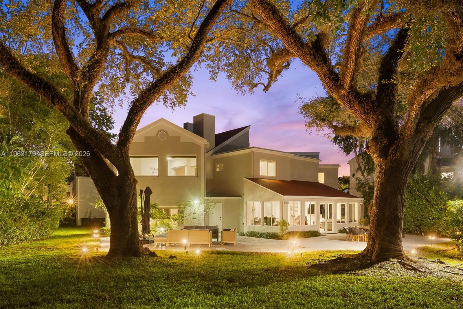 Located in The Chateaux, an exclusive gated enclave in North Miami Beach, this architecturally refined residence blends modern design, volume, privacy, and lifestyle amenities. Renovated, upgraded, and meticulously maintained, the home features soaring ceilings, exposed beams, skylights, and expansive windows that fill the interiors with natural light. Wide-plank flooring and refined finishes anchor the design-forward aesthetic. A striking floating staircase and open mezzanine add depth, while multiple living areas flow seamlessly for entertaining and everyday living. The kitchen offers custom cabinetry, integrated appliances, and generous storage, opening to adjacent dining and living spaces. The primary suite features vaulted ceilings, a spa-inspired bath, expansive custom walk-in closets, and a private sitting area ideal for a lounge or office. Secondary bedrooms are well-sized and thoughtfully designed. Outdoors, a stone patio and manicured lawn framed by mature oak trees create a serene setting. Ideally positioned within the community, the home enjoys direct access to sweeping green space and convenient proximity to the pool. Residents enjoy resort-style amenities including tennis, basketball and soccer courts, fitness center, and playground. Minutes from Aventura Mall, Bal Harbour, beaches, top schools, dining, and major thoroughfares, this exceptional residence offers space, privacy, and refined living in one of North Miami Beach’s most desirable neighborhoods.