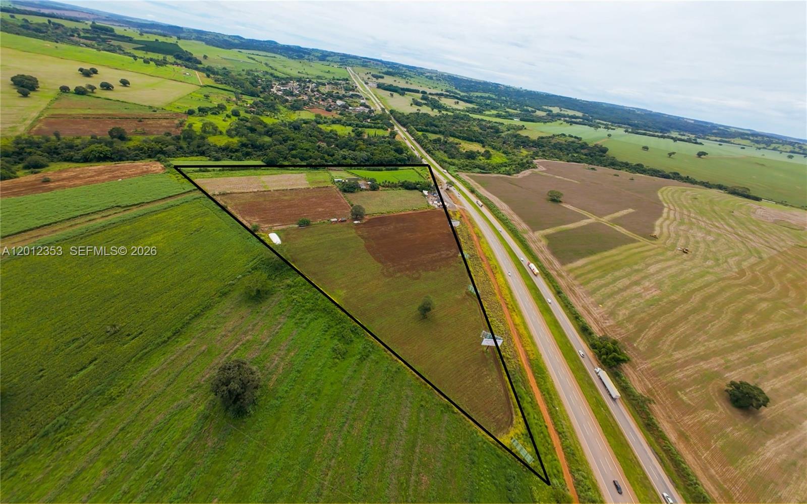 Strategic ±32.4-acre (131,000 m²) development site located along BR-153 in the Goiânia–Anápolis–Brasília corridor—one of the fastest-growing logistics and industrial regions in Central Brazil. The property offers approximately 1,800 feet of direct highway frontage with high visibility and seamless access, supporting large-scale industrial, logistics, and commercial uses.
Positioned within a high-traffic segment of BR-153 with an estimated 40,000–60,000 vehicles per day, the site is well-suited for distribution centers, logistics hubs, transportation operations, warehouses, data centers, and highway-oriented retail.
The asset currently generates income through multiple existing operations, including a restaurant, leased commercial spaces, agricultural production, and on-site solar energy generation, demonstrating immediate revenue potential while allowing for future redevelopment.
Located within a key economic development zone connecting Goiânia, Anápolis (home to a major industrial district), and Brasília, the property benefits from strong regional growth, infrastructure investment, and increasing demand for logistics and distribution assets.
Rare opportunity to acquire a large-scale, high-exposure site with both in-place income and long-term development upside in a supply-constrained logistics corridor.