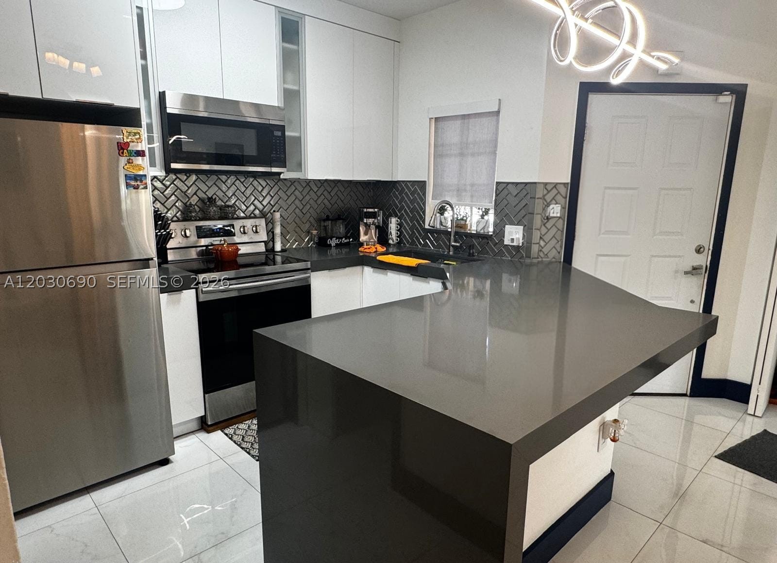 Completely and tastefully remodeled, this first-floor condo in the desirable La Hacienda community offers modern style, comfort, and convenience. Featuring 2 spacious bedrooms and 1 beautifully renovated bathroom, the home boasts an open-concept kitchen with stainless steel appliances, tile flooring throughout, zebra blinds, updated light fixtures, and an in-unit washer and dryer. Enjoy the added convenience of 2 assigned parking spaces, an extra storage area, and a functional layout designed for everyday living. Ideally located in the Hialeah/Miami Lakes area with easy access to shopping, dining, schools, and major highways!