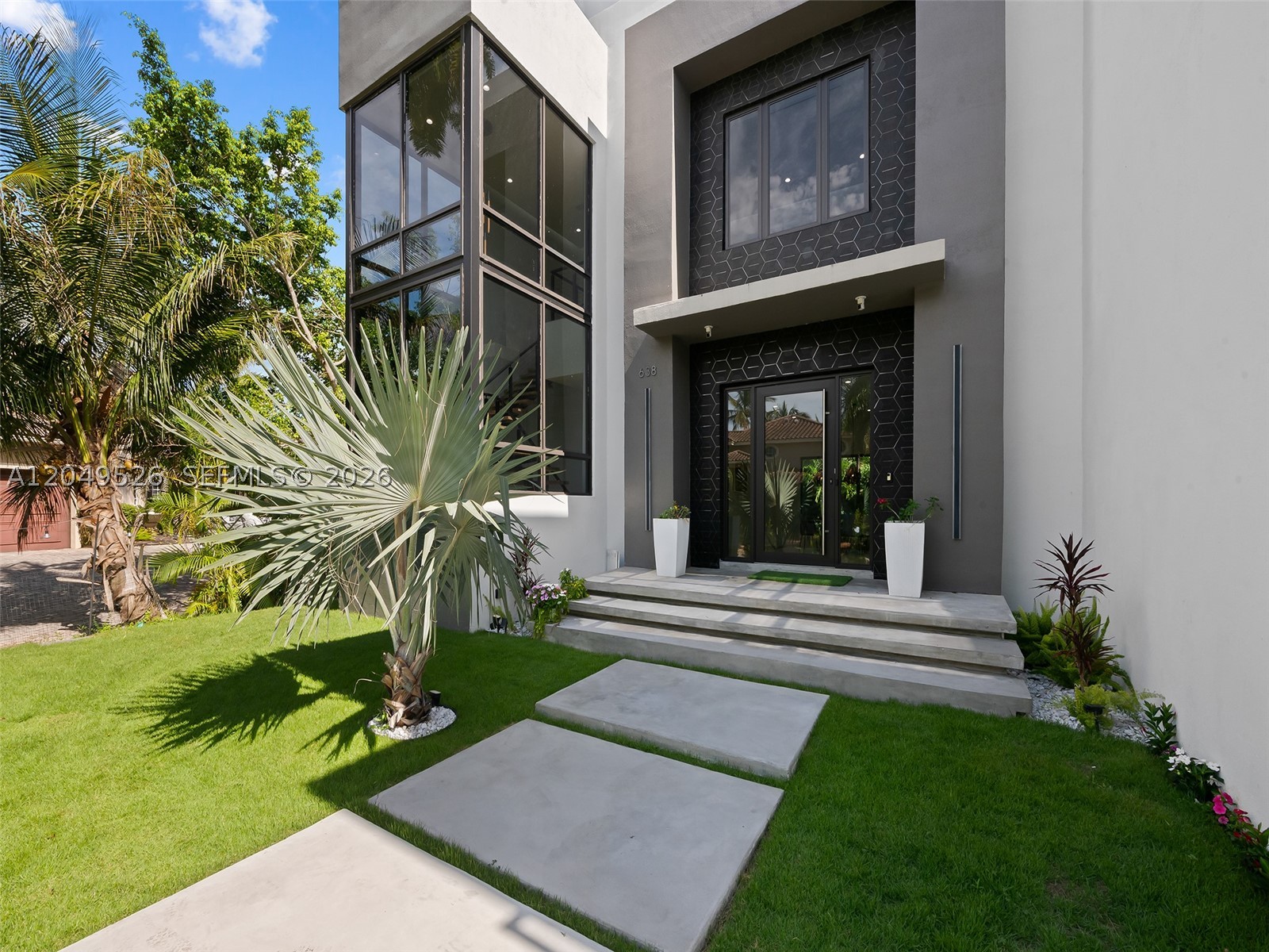 Welcome to 638 Lakeside Harbor, one of South Florida's most forward-thinking new builds — a move-in-ready 4BR/4.5BA coastal retreat east of US-1 in a gated enclave of only 10 homes. Designed by Blue Oval Group and pending certification as one of Florida's first iPHA Passive Homes, it pairs contemporary luxury with future-forward construction, Intracoastal and canal views, water and dock access, and a private community beach. Inside: soaring ceilings, large-format tile, a two-story glass staircase, private elevator, and a chef's kitchen with Dacor and Bosch appliances and a marble island overlooking a living room with statement fireplace. Every bedroom is en-suite; the primary offers a balcony, freestanding tub, water closet, dual vanities, and walk-in closet, while a main-level bedroom doubles as an office or den. A loft, second-floor laundry, smart controls, impact glass, air/water purification, soundproofed walls, an efficient HVAC-ERV system, whole-home generator, dual EV chargers, and solar-ready infrastructure add peace of mind. Outside: a decked patio and separate covered patio overlooking a saltwater pool and waterfall, plus a spiral staircase to a rooftop terrace with summer kitchen and Intracoastal views. Storm-resilient construction and hypoallergenic, mold- and pest-resistant materials — with an estimated 90% energy-cost reduction — deliver a smarter way to live. Minutes from Oceanfront and Oyer Park, Boynton Harbor Marina, Atlantic Avenue, and PBI.