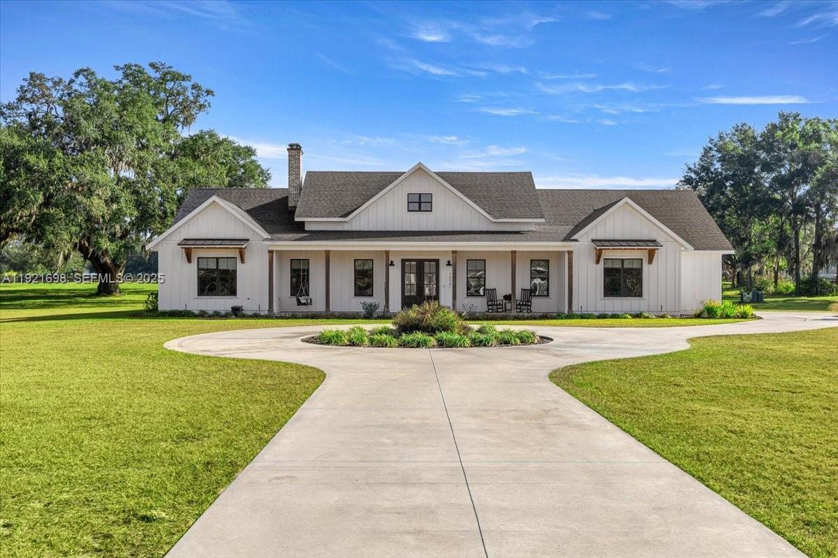 Stunning custom block home on 5.12 acres in gated Sumter Crossing. Built in 2023 with 3,088 sq ft under air, this property offers privacy, efficiency, and high-end design. Features include 10 ft ceilings, 8 ft doors, LVP flooring, custom cabinetry, and a brick wood-burning fireplace with gas starter. The chef’s kitchen boasts quartz countertops, a 48-inch gas range, wine bar, large island, and a walk-in pantry with coffee bar.
Outdoor living includes a full summer kitchen on the covered back porch with brick pavers, and a separate brick-paver front porch offering a warm entry. Fully fenced acreage (2023) with equine and bovine allowed. High-efficiency construction includes Icynene attic spray foam, block with injected foam, dual gas tankless water heaters, and a 24-KW Generac whole-home generator powered by a buried 1,000-gallon propane tank. Low electric bill and well/septic for added savings.
Oversized 2.5-car garage with epoxy floors, two EV charging pre-wires, mechanical room above garage, second attic access, and a 100-amp junction box ready for a barn or guest house. Additional features: salt-filtration water softener, built-in bookshelves, custom cabinetry, mudroom bench, and smart-home systems. AC has 3 zones with a 5-ton unit. Exceptional estate offering space, efficiency, and luxury.