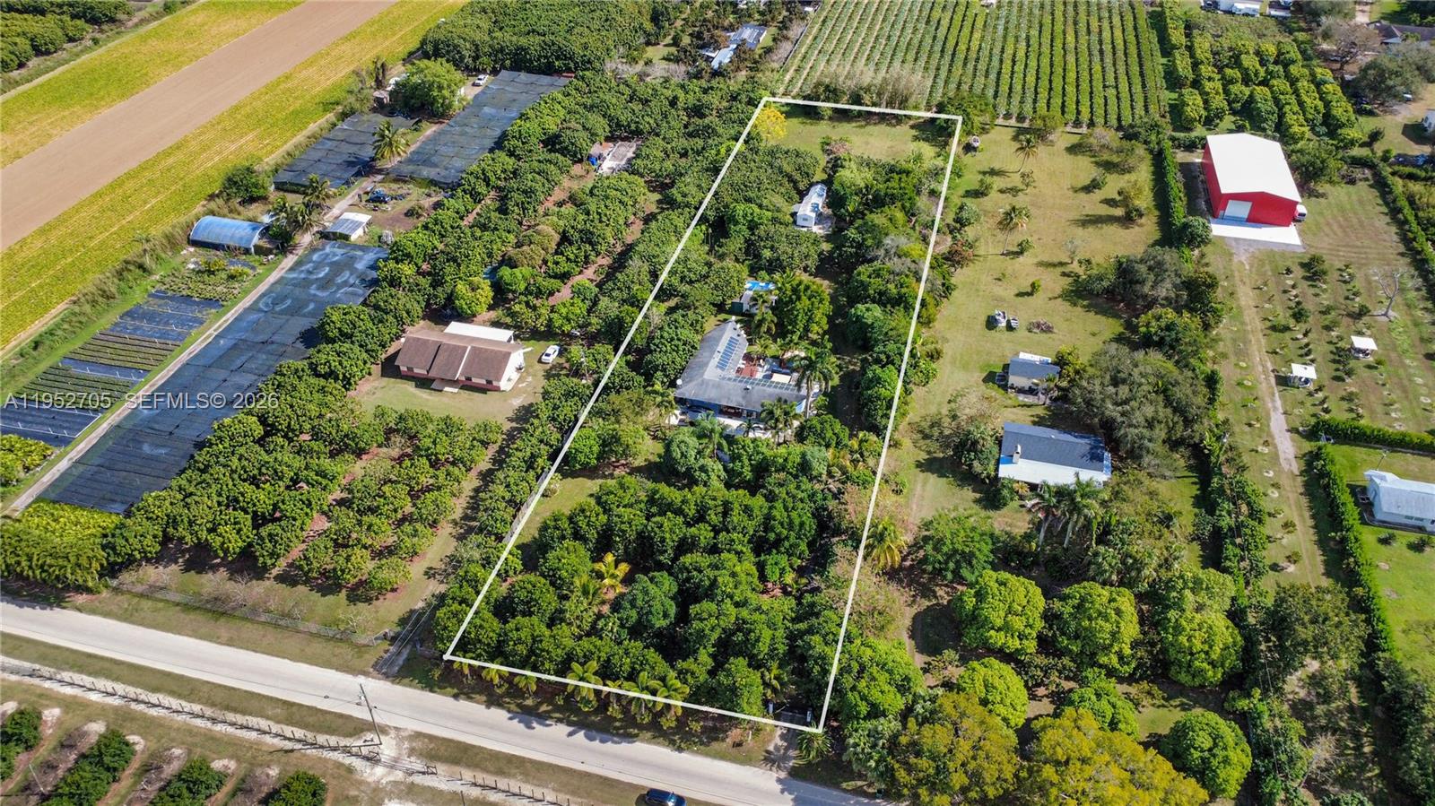 Rare 2.4-Acre Income-Producing Property in Homestead! Endless potential with this multi-use property offering multiple revenue streams, outdoor amenities, and flexibility for residential, rental, or agricultural uses. Whether you’re an investor, short-term rental operator, or looking to live and work on your own land, this Homestead opportunity delivers immediate value with room to grow.

The main residence offers 2,600+ sq. ft. of living space and is ready for renovation or reimagining to suit your needs. On the grounds, you'll find a fully livable 1-bed, 1-bath trailer with kitchen and living area—ideal for rental income or on-site employee housing. A separate workshop with electricity offers space for storage, operations, or creative use.

Outdoor features include a wooden deck with pergola for entertaining, a jacuzzi hot tub, and tranquil koi pond. The fully fenced, irrigated property includes both shaded and open areas perfect for events, gatherings, or expanded agri-use. Solar panels and an EV charger add modern convenience and efficiency.

The owner currently generates income by outsourcing part of the fruit production to a local grower, with opportunity to scale into a full agri-business, nursery, or homestead. The property offers space for additional dwellings, creative landscaping, or continued income-producing ventures. A rare find with built-in income and growth potential—don’t miss it!