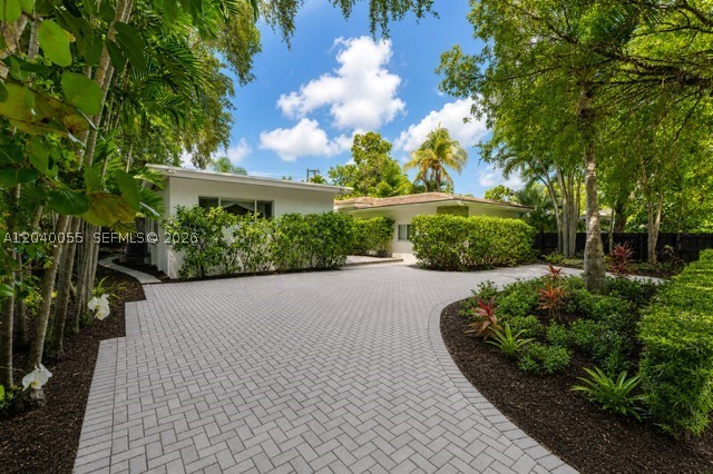 Located on one of Bay Heights' most sought-after streets, this stunning 5-bedroom, 4-bathroom mid-century modern home has been fully remodeled. 3,682sf of beautifully designed living spaces featuring a  flex space/rec room with private entrance, Brazilian cherry hardwood floors, spacious living, family and separate dining areas, and an open-concept kitchen with granite countertops. Beautifully updated bathrooms, full impact windows and doors, and tons of storage throughout. Set on a lush 9,254 SF lot with a concrete privacy wall, ready for your dream garden. Minutes from Key Biscayne, Brickell, Downtown Miami, Coral Gables, and Coconut Grove, with easy access to US-1 and I-95.