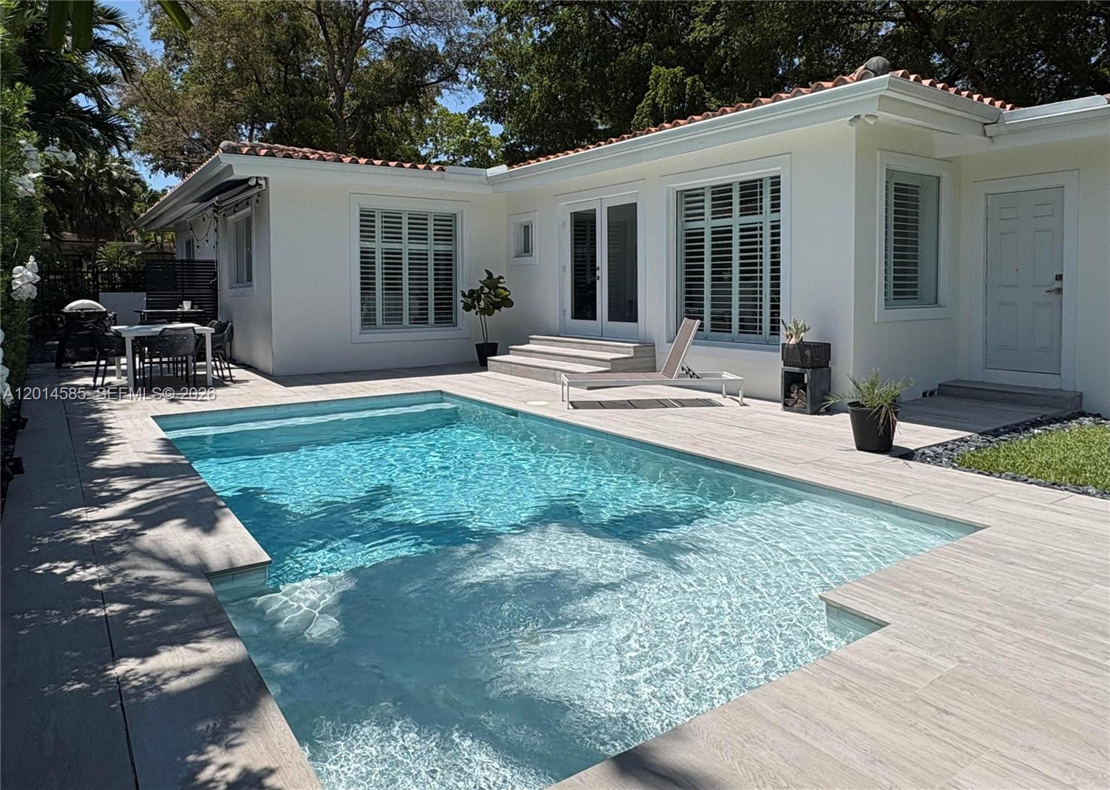 Beautifully renovated 3-bedroom, 2-bathroom home on a quiet corner lot in Coral Gables’ highly sought-after Platinum Triangle. Private backyard features a heated saltwater pool, expansive deck, and lush tropical landscaping creating an exceptional setting for outdoor living and entertaining. Bright living and dining areas feature expansive windows overlooking mature greenery. Updated kitchen includes modern finishes, instant hot water, pot filler, drawer microwave, and premium refrigerator. Family room features a custom walk-in mini bar. Includes garage. Conveniently located near parks, dining, and everyday conveniences, and within the highly regarded Sunset Elementary School boundary.