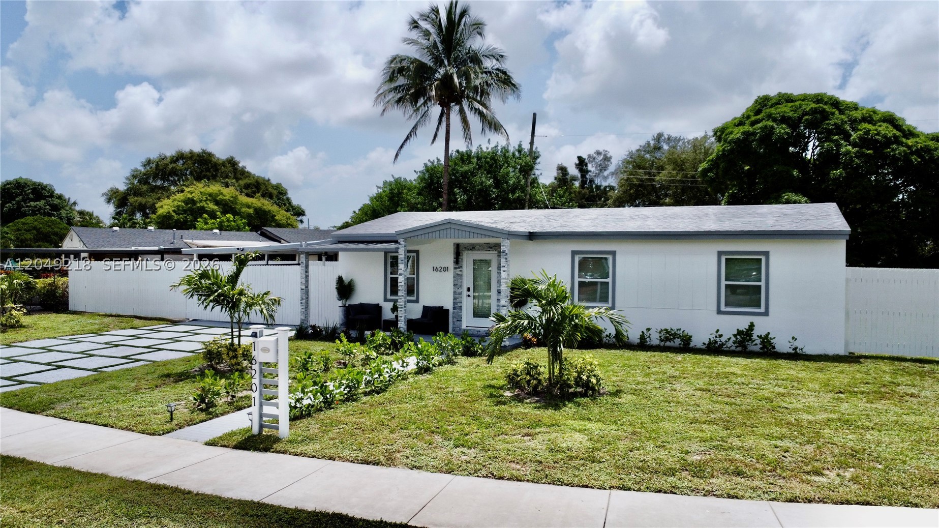 Welcome to this renovated home in Miami Gardens on an oversized 8,399-square-foot lot with curved street frontage and no HOA. The inviting front elevation showcases stacked stone columns and a stacked stone entry surround, creating exceptional curb appeal. Inside, the open-concept living area features a custom media wall with natural oak slat panels, a marble-look accent, a floating media shelf, and integrated LED lighting. The home includes hurricane-impact windows and doors, a newer A/C system, an EcoSmart tankless water heater, recessed LED lighting, and luxury vinyl flooring throughout.

The open-concept kitchen showcases a stainless-steel island range hood, new stainless-steel appliances, including a range, refrigerator, dishwasher, and microwave, plus an integrated breakfast bar with matte black pendant lights for casual dining and entertaining. The modern bathroom features designer tilework, an LED-lighted mirror, and updated fixtures. Outside, enjoy a spacious covered patio with ceiling fans and LED lighting, perfect for entertaining, relaxing, or additional covered parking. The fully fenced backyard features fresh landscaping, a storage shed, and a dedicated laundry room complete with a stackable washer and dryer, plus an indoor utility sink.

With its prime location, the property is just minutes from major highways, Topgolf, shopping, dining, schools, and Hard Rock Stadium. Don't miss this opportunity to own this beautiful home. Schedule your private tour today!