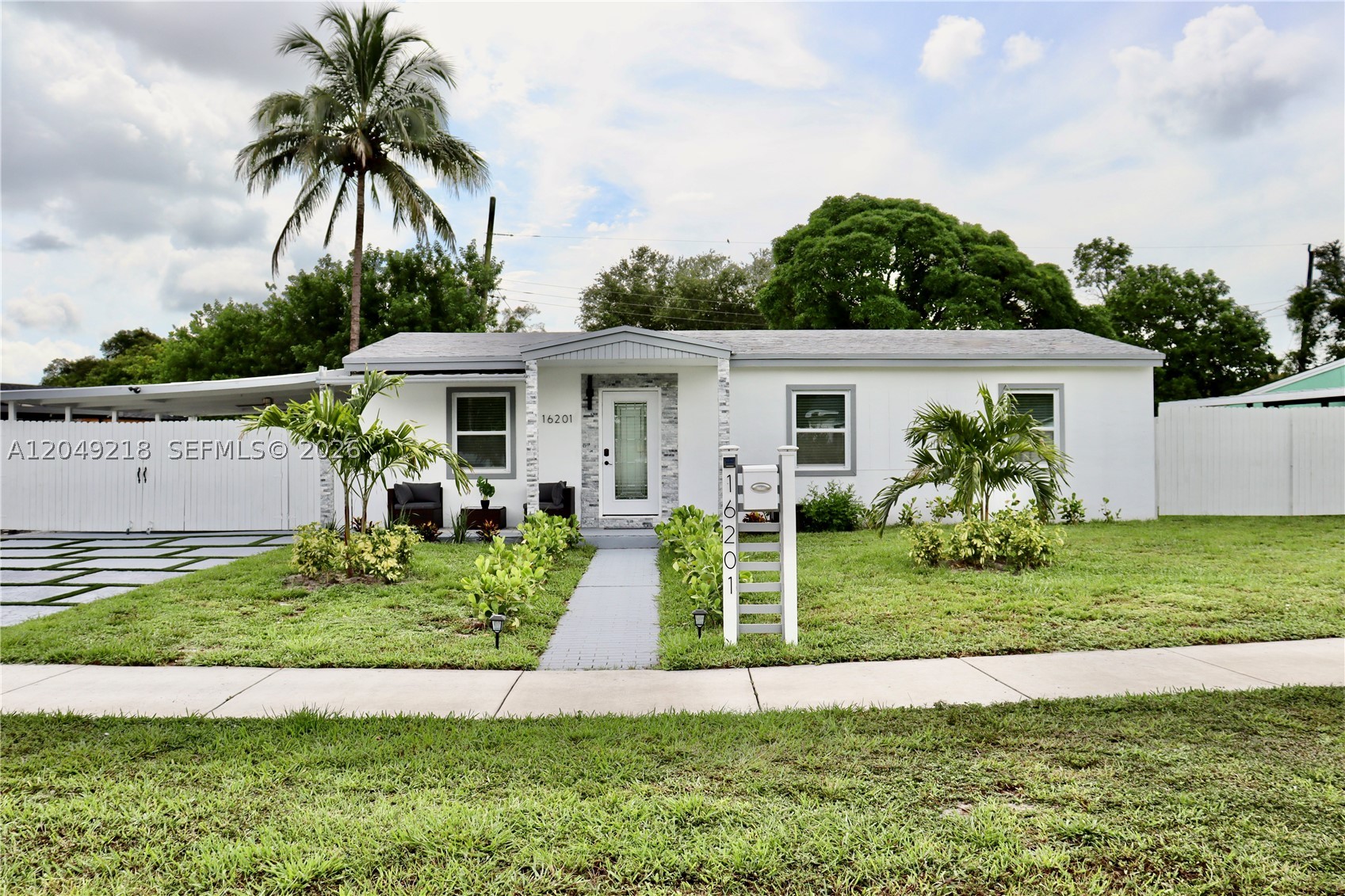 Welcome to this renovated home in Miami Gardens on an oversized 8,399-square-foot lot with curved street frontage and no HOA. The inviting front elevation showcases stacked stone columns and a stacked stone entry surround, creating exceptional curb appeal. Inside, the open-concept living area features a custom media wall with natural oak slat panels, a marble-look accent, a floating media shelf, and integrated LED lighting. The home includes hurricane-impact windows and doors, a newer A/C system, an EcoSmart tankless water heater, recessed LED lighting, and luxury vinyl flooring throughout.

The modern kitchen showcases a stainless-steel island range hood, new stainless-steel appliances, including a range, refrigerator, dishwasher, and microwave, plus an integrated breakfast bar with stylish pendant lights for casual dining and entertaining. The bathroom features designer tile work, an LED-lighted mirror, and updated fixtures. Outside, enjoy a spacious covered patio with ceiling fans and LED lighting, perfect for entertaining, relaxing, or additional covered parking. The fully fenced backyard features fresh landscaping, a storage shed, and a dedicated laundry room complete with a stackable washer and dryer, plus an indoor utility sink.

With its prime location, the property is just minutes from major highways, shopping, dining, schools, Hard Rock Stadium and Topgolf. Don't miss this opportunity to own this beautiful home. Schedule your private tour today!