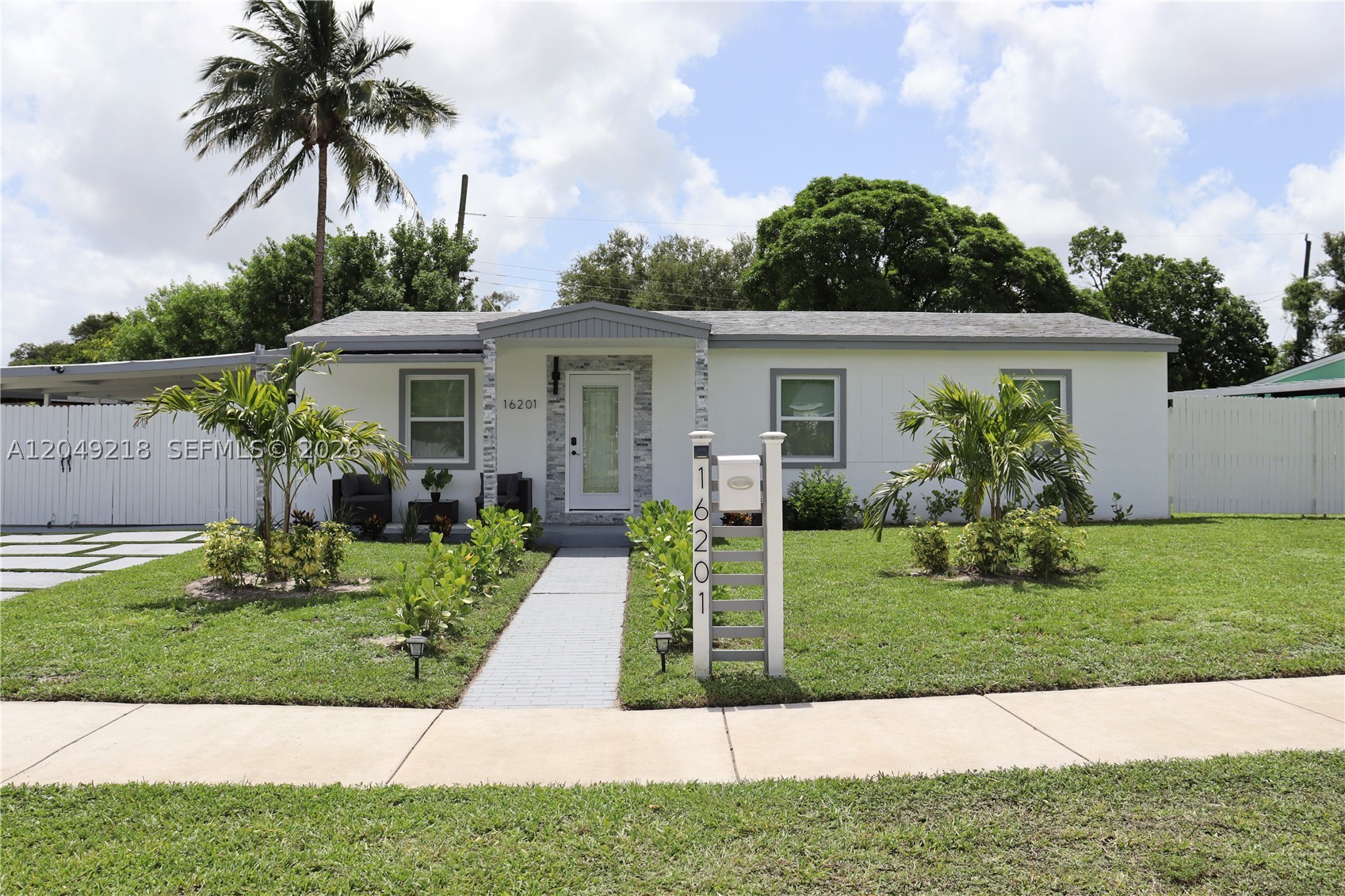 Welcome to this renovated home in Miami Gardens on an oversized 8,399-square-foot lot with curved street frontage and no HOA. The inviting front elevation showcases stacked stone columns and a stacked stone entry surround, creating exceptional curb appeal. Inside, the open-concept living area features a custom media wall with natural oak slat panels, a marble-look accent, a floating media shelf, and integrated LED lighting. The home includes hurricane-impact windows and doors, a newer A/C system, an EcoSmart tankless water heater, recessed LED lighting, and luxury vinyl flooring throughout.

The modern kitchen showcases a stainless-steel island range hood, new stainless-steel appliances, including a range, refrigerator, dishwasher, and microwave, plus an integrated breakfast bar with stylish pendant lights for casual dining and entertaining. The bathroom features designer tile work, an LED-lighted mirror, and updated fixtures. Outside, enjoy a spacious covered patio with ceiling fans and LED lighting, perfect for entertaining, relaxing, or additional covered parking. The fully fenced backyard features fresh landscaping, a storage shed, and a dedicated laundry room complete with a stackable washer and dryer, plus an indoor utility sink.

With its prime location, the property is just minutes from major highways, shopping, dining, schools, Hard Rock Stadium and Topgolf. Don't miss this opportunity to own this beautiful home. Schedule your private tour today!