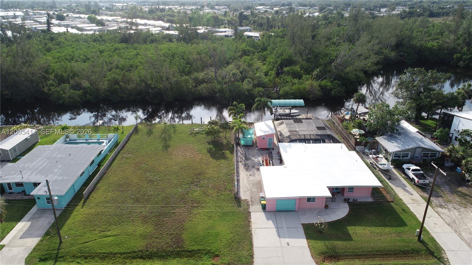 Experience this mid-century waterfront property in Punta Gorda, Florida. This historic small town is a hidden treasure trove of natural beauty, resources, and entertainment. Find yourself in the upper River location 550 yards up a navigable canal to a backwater Bay teaming with aquatic and marine life. Launch from your private boat ramp or get your bay boat off the lift for some salt water time. Canal front amenities include freshwater shore, power, 10K boat lift with canopy, lots of Park space, well lit area. Find yourself at peace in this waterside, classic with southern style charm in an old neighborhood minutes from the creature comforts that this area offers. This property offers a rare blend of privacy serenity, and the off the beaten path that Fla is. This asset features, classic construction and layout of a modified vernacular with a lifestyle of coastal dwelling. Designed a landscape features as low maintenance, CBS and stucco, easy access receptacles, all around impact glass and more! No HOA, live free!