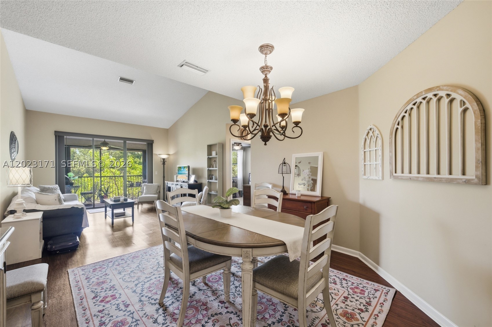Stunning 2-Bed/2-Bath Condo Located In The Desirable Bayview Village Of The Township — TOP FLOOR W/ Easy Elevator Access! Bright & Spacious Open-Concept Layout Featuring Vaulted Ceilings & An Abundance Of Natural Light Throughout. Rich Laminate Wood Flooring Flows Seamlessly Through The Living & Dining Areas, Complemented By Direct Access To The Private Screened-In Balcony— The Perfect Spot To Enjoy Peaceful Treetop Views W/ Morning Coffee & Which Features a Full Size Washer and Dryer. The Updated Eat-In Kitchen Impresses W/ Rich Wood Cabinetry, Granite Countertops, SS Appliances. Dining Area Features An Elegant Chandelier & Plenty Of Space For Entertaining. The Spacious Primary Suite Offers A Ceiling Fan, Direct Balcony Access, Ample Natural Light, & A Walk-In Closet. The En-Suite Primary Bathroom Showcases An Expansive Wraparound White Vanity, Abundant Counter & Storage Space, & A Walk-In Shower. Second Bedroom Also Includes A Ceiling Fan & Comfortable Closet Space — Perfect As A Guest Room Or Home Office. The Second Full Bathroom Features A Clean White Vanity & Shower/Tub Combination. The Unit Is Equipped W/ Impact Windows & Accordion Shutters For Complete Hurricane Protection, Plus A Brand New 2025 AC System W/ A Smart Thermostat For Year-Round Comfort & Efficiency. Perfectly Located Less Than 5 Minutes From The Promenade W/ Endless Shopping & Restaurants. This One Has It All — Schedule Your Showing Today!