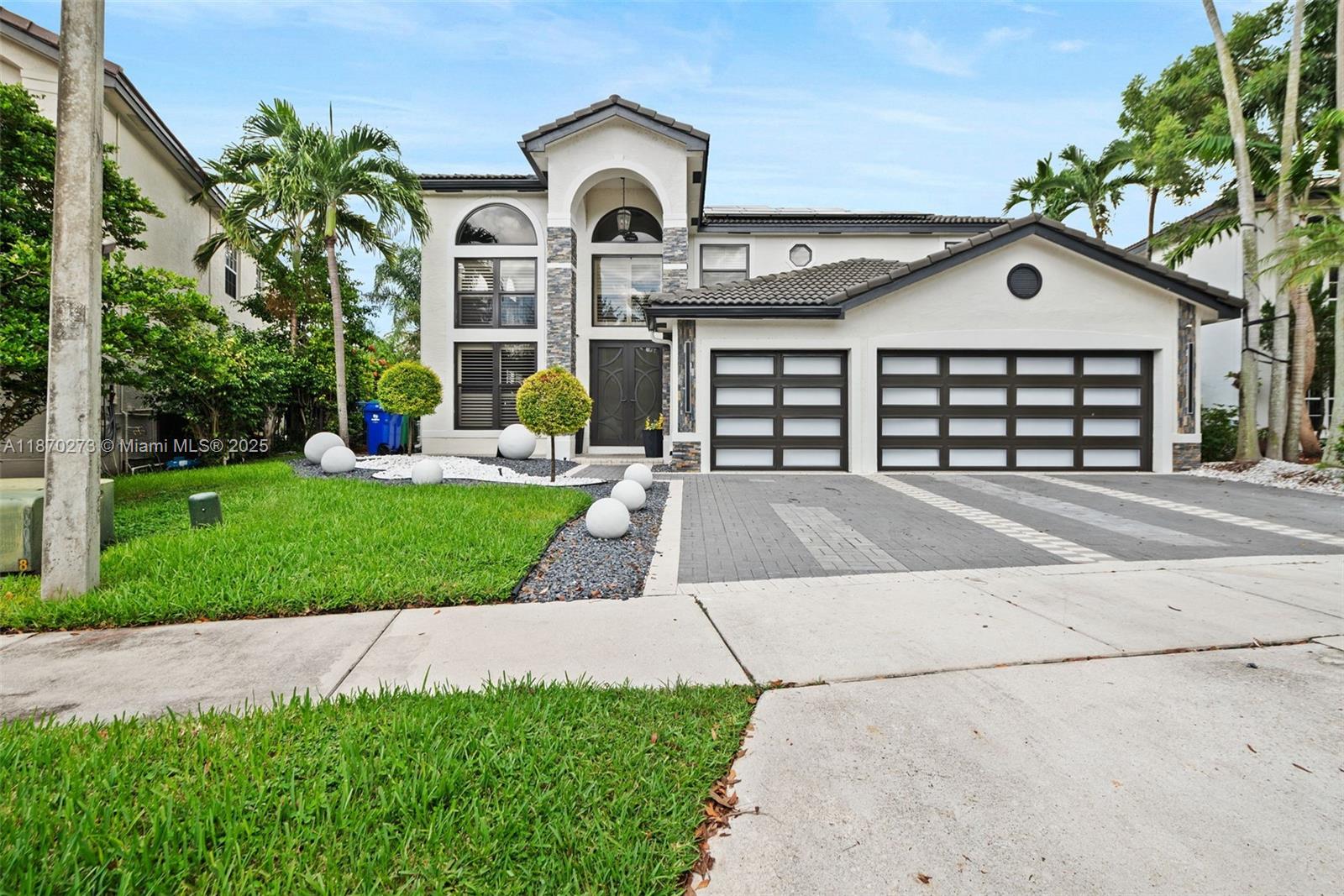Stunning 6BD/4.5BA lakefront estate where no expense was spared in the remodel. This home features sleek porcelain floors, designer finishes, custom closets, and a spa-inspired primary suite with freestanding tub & oversized shower. Light-filled living spaces flow seamlessly into a gourmet kitchen and private gym area. Outdoors, enjoy a resort-style pool, covered pergola with full summer kitchen & bar, perfect for entertaining or watching the big game. Expansive lake views create the ultimate South Florida lifestyle. We have the perfect space for you in-laws ; The garage is beautifully converted into a bedroom and massive closet but can very easily be converted back to a 3 car garage. Enjoy lower energy cost with solar panels owned by the seller that will transfer to the new buyer.