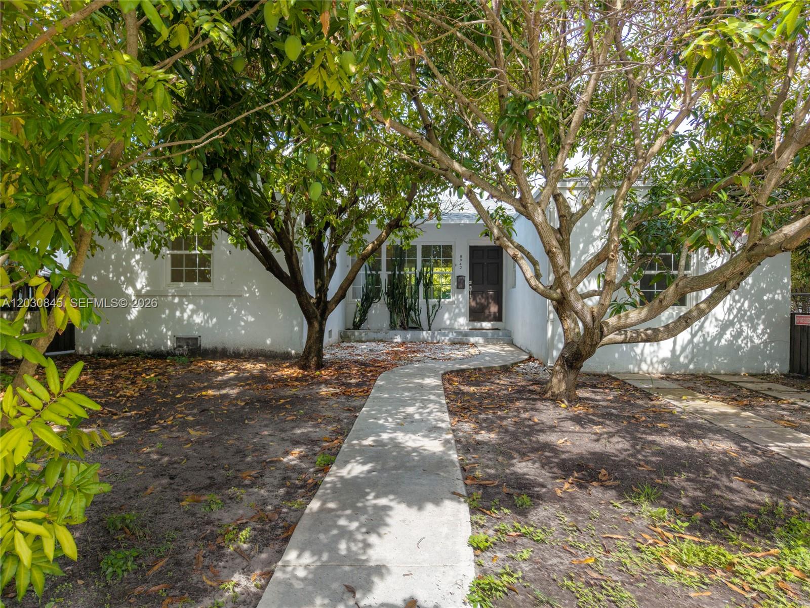 Welcome to your Surfside sanctuary at 8942 Carlyle Ave, perfectly situated in one of Miami’s most desirable neighborhoods. This spacious, sunlit home effortlessly blends timeless rustic charm with modern coastal living. Step inside to discover beautifully maintained wood floors that flow through a bright and open layout.

The heart of the home is a chef’s dream, equipped with a professional-grade gas stove and oven, perfectly accented by a large retro farmhouse kitchen sink. The rustic elegance extends to the beautifully remodeled retro/vintage-style bathrooms featuring classic pedestal sinks.

Outside, your private tropical oasis awaits. The expansive backyard features mature fruit trees and offers more than enough space to build your custom dream pool. Enjoy the ultimate freedom of homeownership with absolutely no HOA.

The lifestyle and location are truly unmatched. You are just four short blocks from pristine beaches and the legendary Four Seasons Surf Club. Live steps away from Surfside’s upscale boutiques, fine dining, and unique community charm. The property is mere minutes from the Surfside Community Center—offering access to two beautiful pools and the beach—and is conveniently close to local houses of worship. The home is zoned for the highly coveted, A-rated Bay Harbor Schools.

Please view the comprehensive 3D/360 virtual tour for a complete walkthrough and more details!