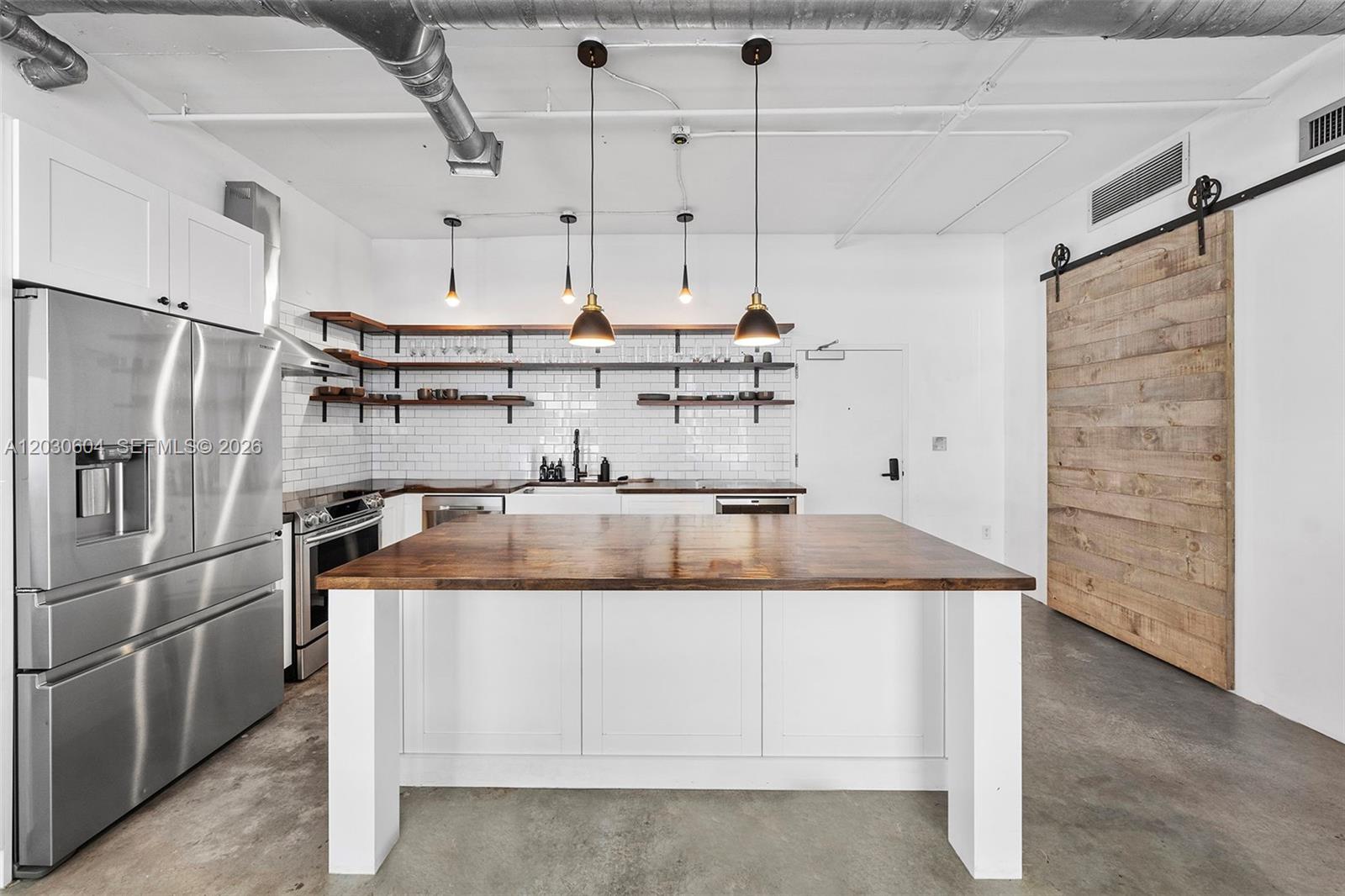 Authentic loft living in the heart of Edgewater. Defined by soaring ceilings, exposed ductwork, polished concrete floors, and expansive open living spaces, this oversized 1-bedroom, 2-bath residence seamlessly blends industrial character with modern sophistication. The thoughtfully redesigned chef’s kitchen serves as the centerpiece of the home, featuring custom wood countertops, open shelving, subway tile backsplash, stainless steel appliances, and a generous island perfect for entertaining.

Natural light pours through oversized windows, illuminating the loft’s clean architectural lines and airy layout. The spacious primary suite offers a large walk-in closet and en-suite bath, while the second full bathroom provides added flexibility for guests or a home office lifestyle. A private balcony extends the living space outdoors.

Rarely available and rich in character, this residence offers the feel of a converted New York warehouse loft while placing you moments from Midtown, the Design District, Wynwood, Downtown Miami, waterfront parks, acclaimed dining, and world-class shopping. A truly distinctive offering for buyers seeking style, space, and location in one of Miami’s most vibrant neighborhoods.