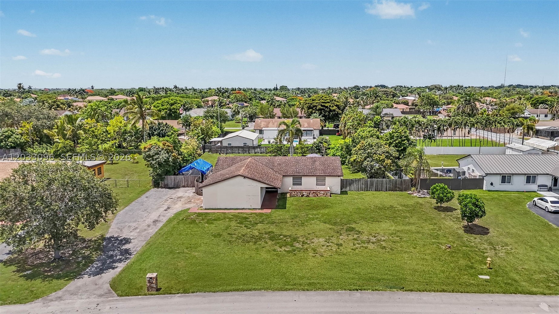 Stunning Ranch-Style Oasis in Westbury Estates! Welcome to your tropical paradise in the highly sought-after Westbury Estates neighborhood of Homestead. Situated on a sprawling 0.5+ acre lot with no HOA, this beautiful ranch-style pool home features 3 bedrooms, 2 bathrooms, plus a highly versatile convertible bedroom/office suite. The interior shines with elegant porcelain tile flooring throughout the main living areas and warm wood laminate in the bedrooms. Step outside into your private, fenced backyard filled with mature fruit trees—including various species of mango, anon, avocado, and lemon—and dive into the magnificent, recently redone oversized pool. Complete with a 2-car garage and plenty of room to park your boat or RV, this property offers ultimate freedom and resort-style living.
