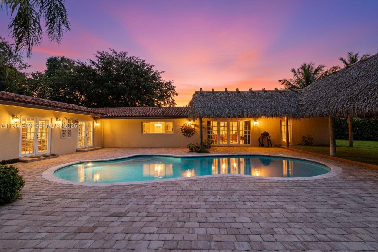New Price! Spacious 6BD 4BA estate on oversized 30,928 sq ft lot, located on quiet cul-de-sac in one of Northeast Palmetto Bay’s most desirable neighborhoods. Tropical compound offers exceptional indoor and outdoor entertaining, multigenerational living, and income-producing potential. Large paver driveway fits numerous vehicles and a boat, complemented by detached three-car garage that can be converted to in-law suite. Home features hardwood and marble floors, impact windows and doors, plantation shutters, and multiple living areas with open layout. Chef’s kitchen offers 48-inch professional-grade gas range with built-in griddle and double oven, copper farmhouse sink, oversized island, stainless steel appliances, commercial-grade refrigerator, Electrolux wine and beverage cooler, pantry, and ample cabinetry. Formal living and dining rooms flow into spacious family room, ideal for entertaining. Primary suite includes direct backyard access, large his-and-hers closets, and spa-style bath with dual vanities, soaking tub, oversized walk-in shower, and marble floors. Flexible layout includes private in-law quarters with refrigerator & large sixth bedroom ideal for movie theater, game room, or rental use. Backyard features resort-style pool, large tiki hut with bar, & expansive green space for gatherings. Rear accessory dwelling with own utilities offers rental or guest income. Close to top private schools, A+ public schools, Coral Reef Park, & Deering Estate. Seller is motivated