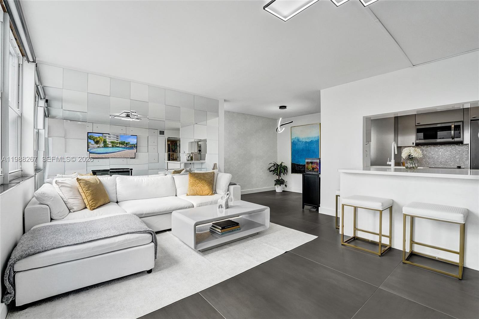 Experience the epitome of modern luxury at the Golden Isles Yacht Club. This impeccably reimagined residence showcases a bespoke remodel where every detail has been thoughtfully considered. Gleaming 48x48 porcelain tiles stretch effortlessly across the entire space, setting the stage for Venetian plastered walls, textured wallpaper accents, electric blinds, and sleek modern light fixtures. A stunning mosaic beveled mirror adds an artistic flourish, elevating the home’s contemporary sophistication. The kitchen is a chef’s dream, featuring an expansive island topped with pearl metallic white countertops, complemented by chic built-in white lacquer and brushed nickel cabinetry. State-of-the-art stainless steel appliances and wine cooler. Plus, a top-tier water filtration system provides pristine water directly from your tap. The primary suite is a serene retreat with two generous walk-in closets, while the spa-inspired bathrooms offer lighted mirrors and elegant top-mounted glass sinks. Outside, unwind by the pool or take advantage of the community dock with boat slips available for your nautical adventures. And the best part? You're just a short stroll away from the sun-kissed sands of the beach. This is more than a home—it’s a lifestyle.