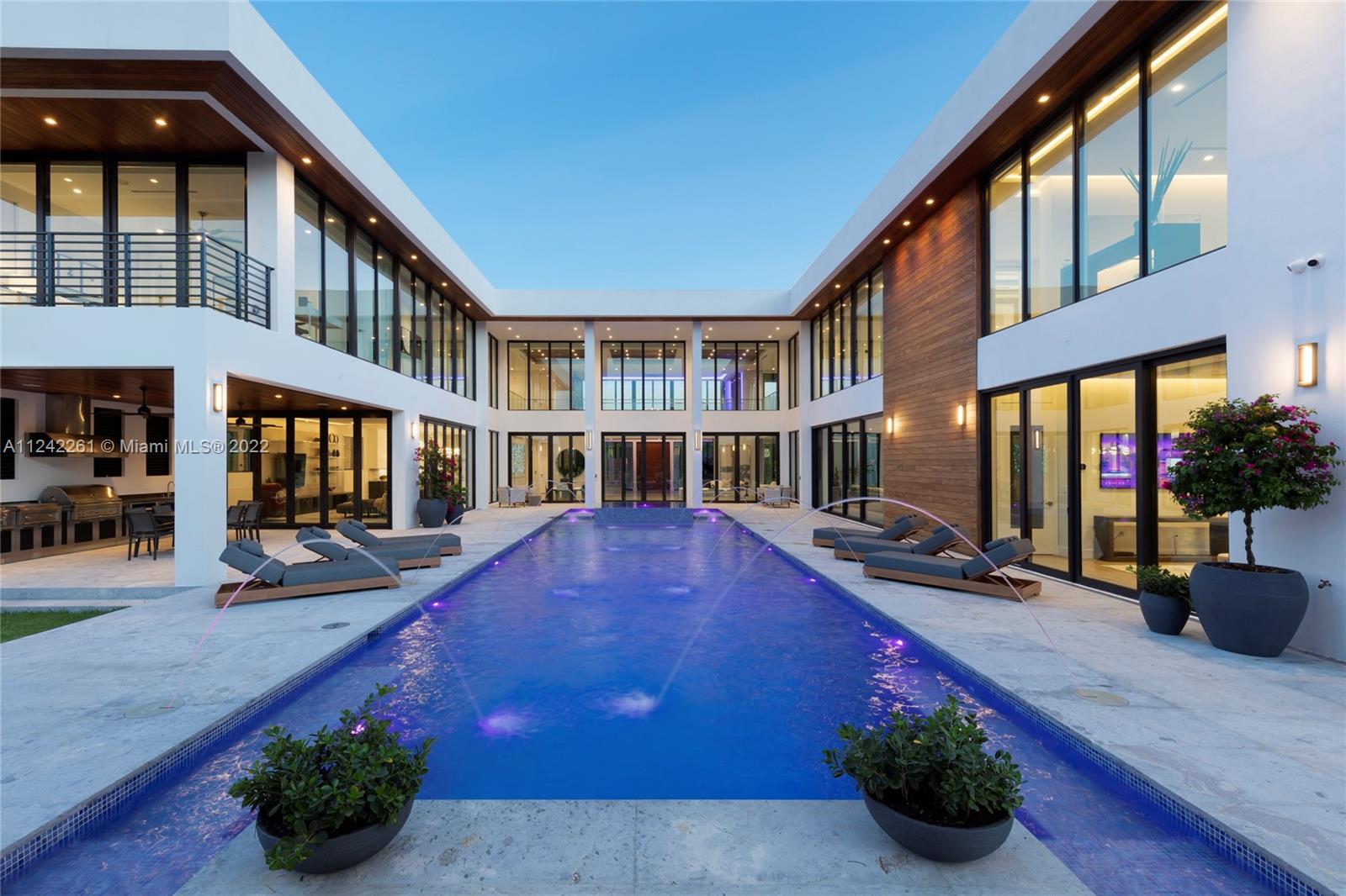 A North Pinecrest modern masterpiece that effortlessly blends elegance and nature. Through walls of glass, take in 360 views of tranquil water elements, sunlight, and foliage. Newly completed, this estate features smart home technology, high end finishes, home theater, elevator, large den, two driveways & thoughtful extras. The 1,300 SF primary suite will exceed expectations with wraparound windows, sitting area, spa-like bathroom & walk-in closet with laundry. Experience seamless indoor/outdoor living with folding glass doors opening to your 75’ tiled pool and jacuzzi, summer kitchen with electric screens, and cabana with dramatic marble slabs & full bath. Wood and lighting accents flow from outside to in, adding warmth to the sleek design. This Pinecrest home is in a class all its own!