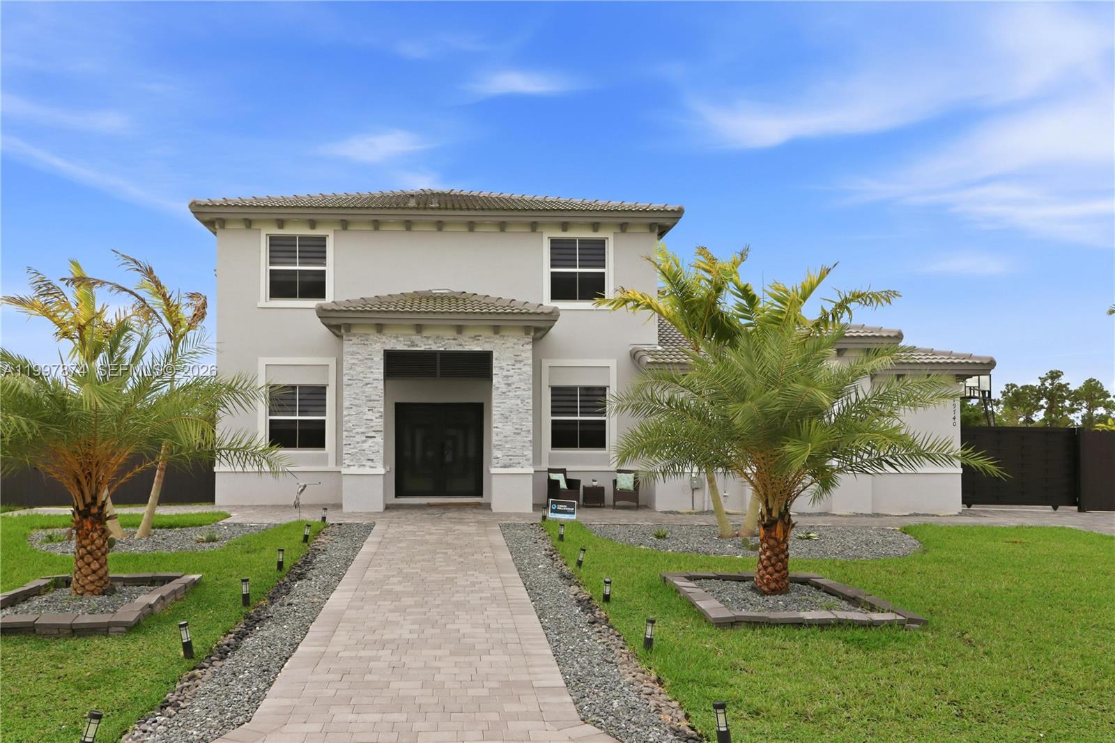 Experience modern luxury in this stunning, newly constructed 2024 residence located in the heart of Homestead. This home is a showcase of contemporary design, featuring sleek marble floors, elegant recessed lighting, and stylish modern light fixtures throughout. The gourmet kitchen is a chef’s dream, anchored by premium quartz countertops, while the main living areas are elevated by a sophisticated accent wall. For ultimate peace of mind and energy efficiency, the home is fully equipped with impact-resistant windows and doors, complemented by chic zebra blinds for perfect light control. The thoughtfully designed floor plan offers versatility and comfort, including a convenient first-floor bedroom and full bath, perfect for guests or an office. Upstairs, the sprawling primary suite serves as a true sanctuary with architectural tray ceilings, while a second spacious bedroom also features its own private en-suite bathroom. Practicality meets style with a three-car garage, providing ample storage and parking. Outside, the property sits on a massive lot offering a sprawling backyard with limitless potential—perfect for those dreaming of designing a custom pool, lush tropical gardens, or a private orchard of fruit trees. This turn-key masterpiece combines high-end finishes with the space and freedom to create your own outdoor oasis.