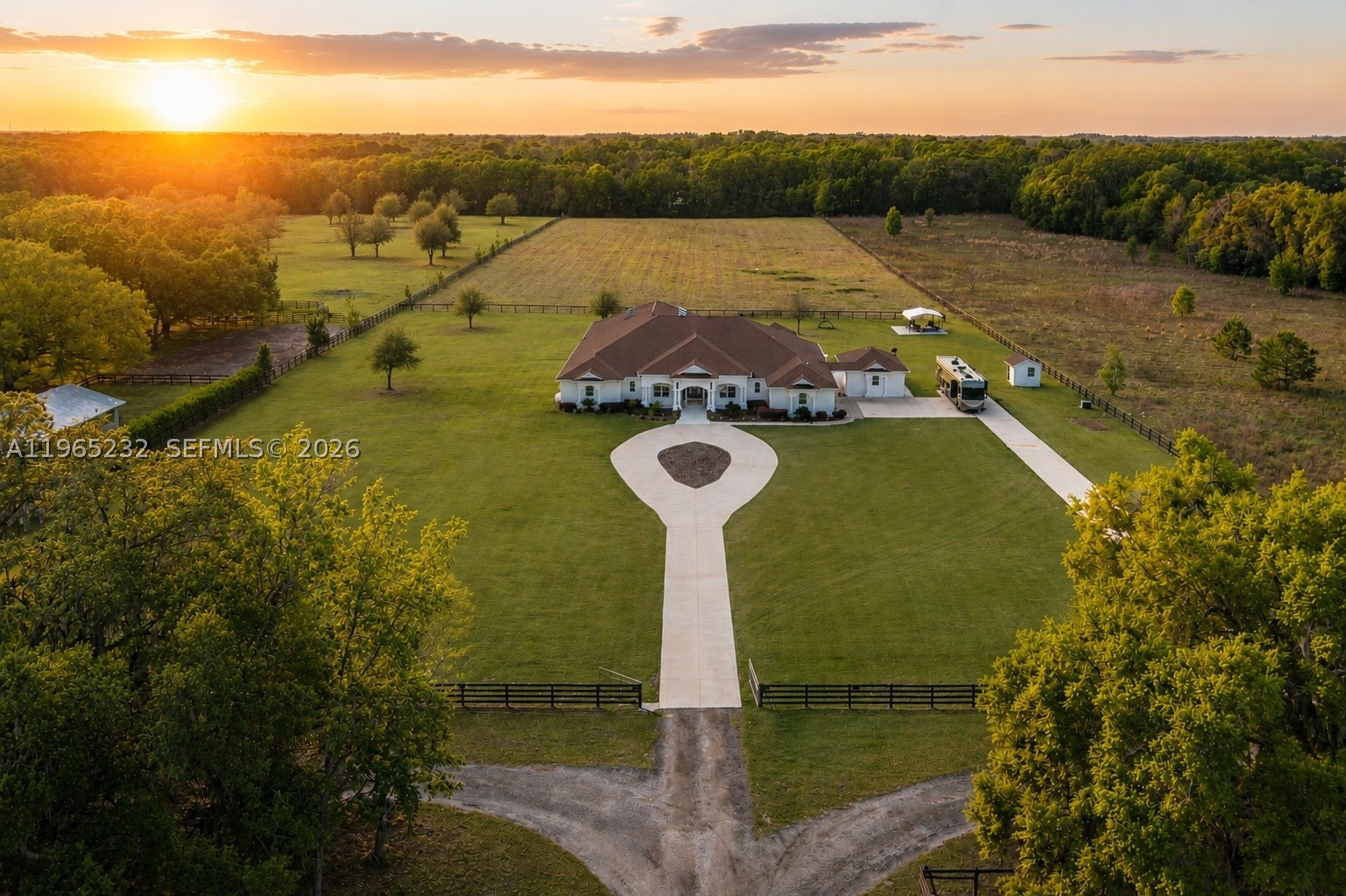 Set on approximately 10.47 fully fenced acres in Ocala’s premier countryside, this private estate offers refined living with exceptional equestrian potential, just minutes from the World Equestrian Center, Golden Ocala, and Adena Golf & Country Club. The 6,100+ sq ft main residence features soaring ceilings, abundant natural light, and Italian porcelain tile throughout. The chef’s kitchen showcases dual oversized islands, Brazilian marble countertops, premium appliances, and a gas range. The primary suite includes a sitting area, fireplace, patio access, dual walk-in closets, and a spa-style bath. Additional highlights include an expansive indoor pool and spa, covered outdoor living with summer kitchen, and a separate guest cottage. Zoned A-1, allowing horses and future barns or paddocks.