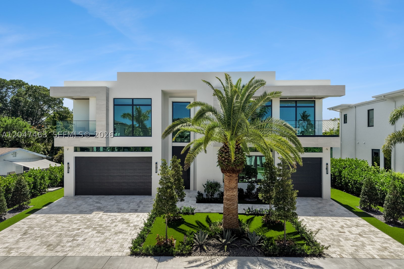 Introducing 1051 NE 2nd Terrace, an exceptional new construction residence by Empire Development, offering 6,404 total sqft of contemporary luxury in the heart of downtown Boca Raton. A dramatic 24 FT foyer welcomes you into an open floor plan w/ soaring ceilings, walls of floor-to-ceiling glass, & a striking Canary Island date palm as its architectural centerpiece. The first floor features 48” x 48” Italian porcelain, while the second level is finished w/ wide-plank white oak flooring, connected by a custom staircase. Solid-core white oak doors, Watermark plumbing fixtures, & designer finishes elevate the home. The chef’s kitchen is appointed w/ Wolf natural gas appliances, Sub-Zero refrigeration, Taj Mahal quartzite countertops & backsplash, & an oversized walk-in pantry wrapped in matching Taj Mahal quartzite. The home offers five ensuite bedrooms, a spacious first-floor club room, & a luxurious primary suite with a sitting area, morning bar, private balcony, custom millwork, & a spa-inspired marble bath. Designed for year-round entertaining, the backyard features a large saltwater pool & spa, a covered summer kitchen w/ Wolf and Sub-Zero appliances, & generous outdoor living spaces. A three-car garage with lift-height ceilings completes the home. Ideally located minutes from Mizner Park, The Boca Raton, premier dining, shopping, & Boca Raton’s beaches, 1051 NE 2nd Terrace offers an exceptional opportunity to own one of downtown Boca Raton’s finest new luxury residences.