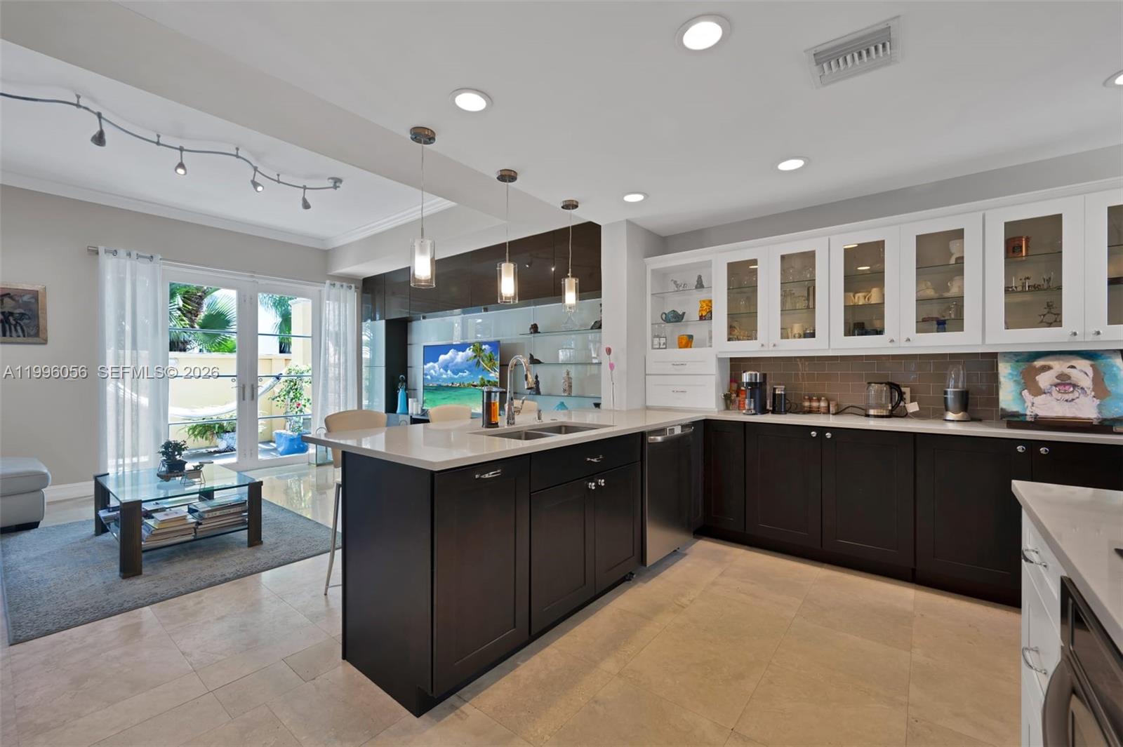 Discover one of the most desirable townhomes in Aventura, offering the largest 3-bedroom floor plan in the elegant Mediterranean-style community of Aventura Bay. Beautifully renovated and exceptionally spacious, this residence is one of only six homes with a private double-car garage, providing rare convenience for everyday living. The home features an immaculately redesigned kitchen, refined finishes, a custom built-in wall unit in the living room, warm wood flooring in the secondary bedrooms, and a recently modernized primary suite with soaring 14-foot ceilings. Perfectly positioned directly across from Veterans Park near the entrance of Williams Island, this home offers a peaceful, pet-friendly setting in a vibrant, young community in the heart of Aventura. Enjoy a short car ride to the beach, premier shopping and dining at Aventura Mall, convenient access to major highways, A-rated schools, and walking distance to houses of worship. The gated Aventura Bay community is meticulously maintained and has completed major improvements within the past two years, including new roofing, exterior painting, updated stone façade moldings, and beautiful new landscaping throughout. With generous living space, a private garage, a park-front location, and a prime central Aventura lifestyle, this exceptional residence is a rare opportunity in one of the city’s most sought-after communities. Motivated sellers.