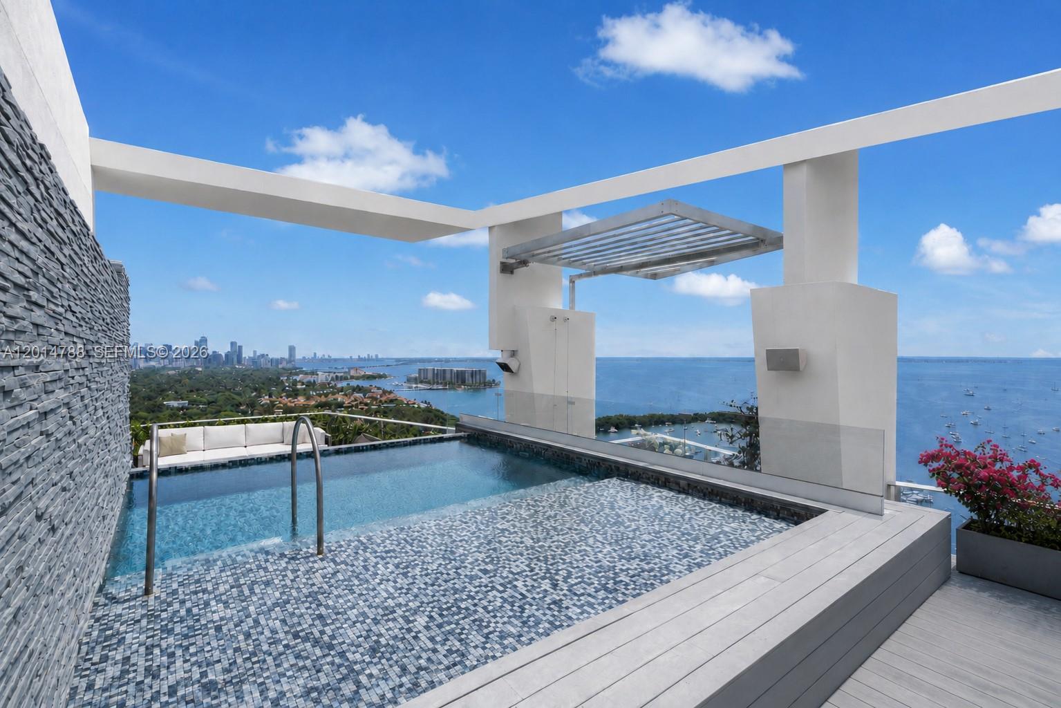 Positioned high above Coconut Grove, this remarkable 11,810 SF penthouse at Grovenor House defines contemporary waterfront living. Encompassing 5 bedrooms and 5 full plus 3 half baths, the residence is crowned by a private rooftop retreat complete with its own pool and sweeping panoramic views of Biscayne Bay and the Miami skyline. Thoughtfully designed with a balance of sophistication and comfort, the interiors showcase intricate ceiling details, bespoke millwork, and rich hardwood flooring. A temperature-controlled wine cellar with capacity for over 300 bottles complements the custom-designed chef’s kitchen. Expansive floor-to-ceiling glass doors lead to a generous wraparound terrace, creating a seamless indoor-outdoor experience. Additional highlights include private elevator access, a rooftop summer kitchen with service lift, automated window treatments, and a fully integrated smart home system, delivering a truly elevated residential experience. Residents of Grovenor House enjoy access to world-class amenities including an infinity-edge pool with private cabanas and wet bar, a full-service spa, state-of-the-art fitness center, tennis court, meditation and Zen gardens with lush banyan and oak trees, entertainment lounge with catering kitchen, children’s playground, dog park, and 24-hour concierge, valet, and security services. The building also offers the exclusive “Grovenor Link” concierge technology service.