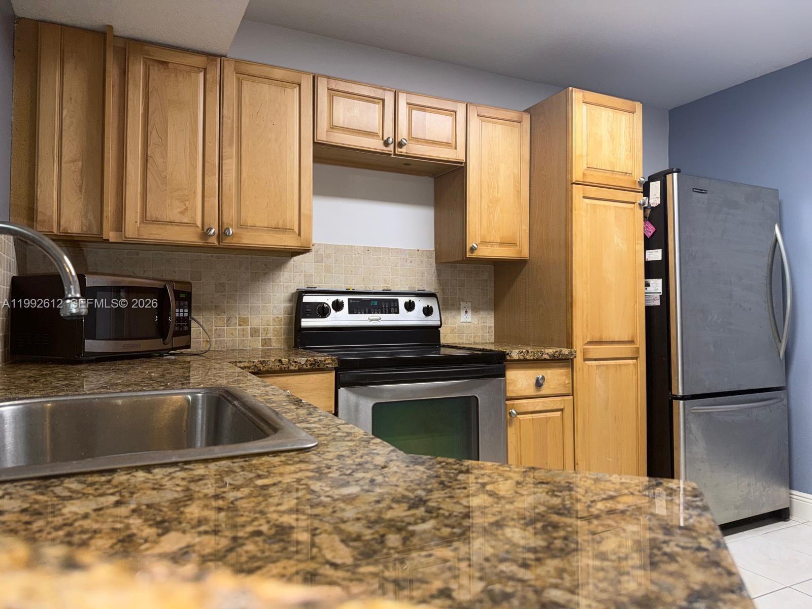 Beautiful 2-Bed, 2-Bath Condo in Edgewater Community. Located on the first floor with vaulted ceilings, this spacious condo offers a bright and open living area with a separate dining space and a split-bedroom floor plan for added privacy. The updated kitchen features wood cabinetry and granite countertops. Enjoy wood and tile flooring throughout the main living areas. Additional conveniences include a laundry room with washer and dryer in the unit. This pet-friendly, amenity-rich community offers a pool, tennis courts, clubhouse, fitness center, and more.
