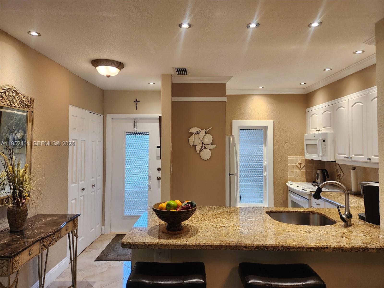Stunning first-floor condo featuring 2 master bedrooms with a beautiful lake view, located in a quiet corner setting. The corner location adds extra windows, filling the home with natural light. Open kitchen with granite countertops. Enjoy direct access from the Florida room to the walking area, pool, community amenities, and lake. Tile flooring throughout. Upgraded bathroom with spacious walk-in shower and independent entrances for each bedroom.55+ Community .Al furniture and accessories are included in the sale.