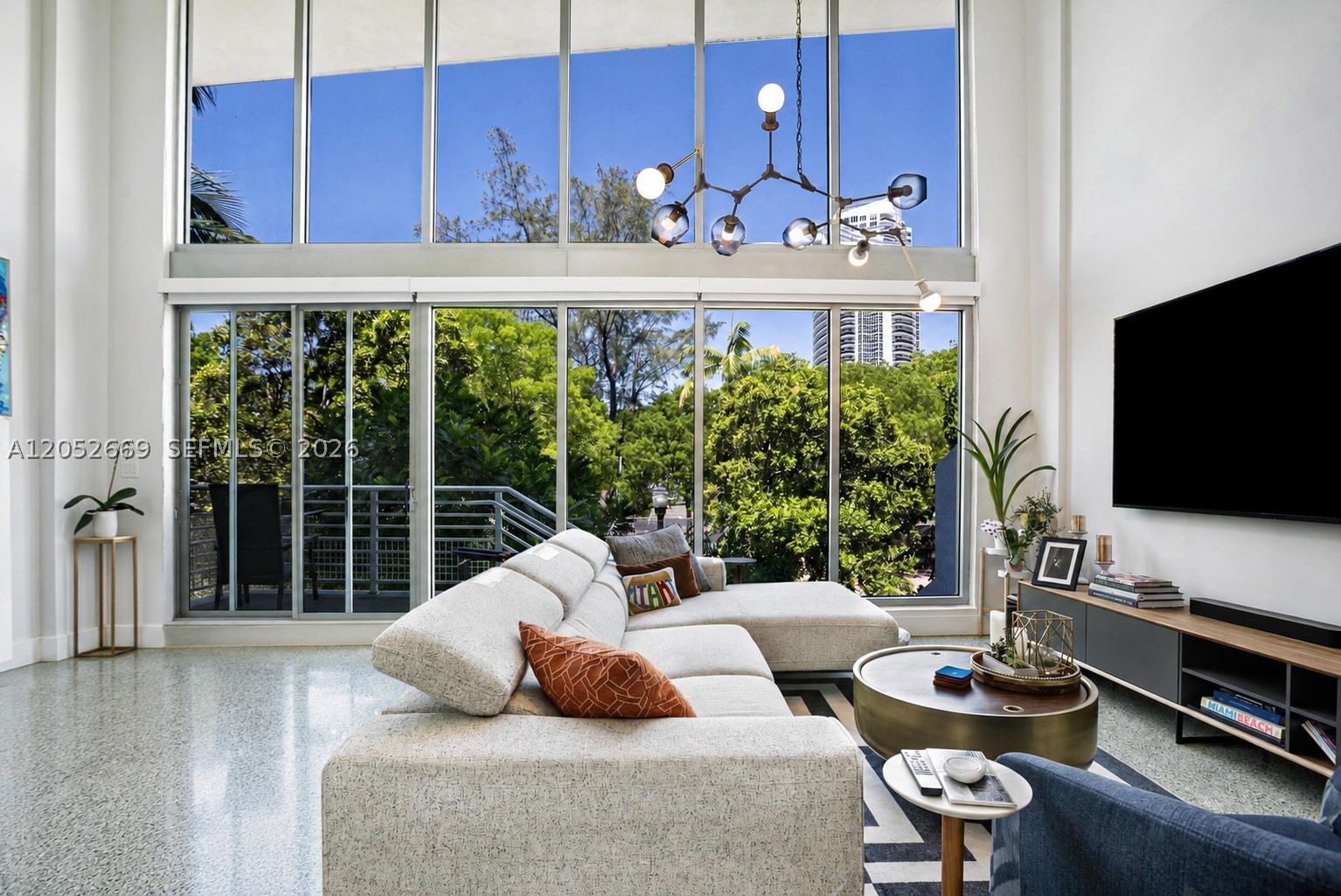 Experience elevated living in the largest residence in the boutique ABSOLUT, ideally situated on a quiet, tree lined street in Miami Beach's coveted South of Fifth neighborhood. This rarely available 3 bedroom, 3 bathroom loft offers one of the area's most desirable floor plans, combining dramatic architecture with modern sophistication.

Showcasing striking 18 foot ceilings, floor to ceiling hurricane impact glass, elegant terrazzo floors, and automated electric shades throughout, the home is filled with natural light and designed for effortless living. The expansive open concept layout flows seamlessly into a sleek contemporary kitchen, creating the perfect setting for both everyday living and entertaining all combined with a low HOA fee!

The spacious primary suite serves as a private retreat, while the home's exceptional indoor outdoor connection sets it apart. Enjoy your own lush private garden with the rare convenience of direct street access or entry through the building's gated entrance, offering the feel of a private home while enjoying the amenities of a boutique condominium.

Additional highlights include assigned parking, rooftop access, and a resort style pool. Just three blocks from the beach and one block from the marina, this exceptional residence places you moments from South Pointe Park, world class dining, boutique shopping, fitness studios, and the vibrant South of Fifth waterfront lifestyle.