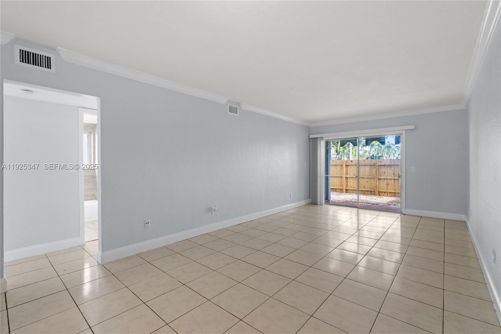 Sunlit and welcoming corner 2BR/1BA with ground-floor entry and a private fenced backyard. This residence features high ceilings, tile flooring throughout, and large windows in every room, including the kitchen and bathroom, for beautiful natural light. The spacious living area opens directly to the backyard, creating an easy indoor–outdoor flow, with a second access point from the primary bedroom. The primary suite includes a walk-in closet, while additional closets throughout the condo provide generous storage. The kitchen offers wood cabinetry, granite countertops, abundant storage, a dishwasher, and an electric range. The modern bathroom includes a bathtub/shower combo, a window for natural ventilation, and updated tile finishes that complement the home’s clean aesthetic. Additional highlights include central A/C and convenient street access from the private yard, a unique feature for condo living. Located in the Olas Azules community with on-site laundry facilities and easy access to local shops, dining, and major roadways.