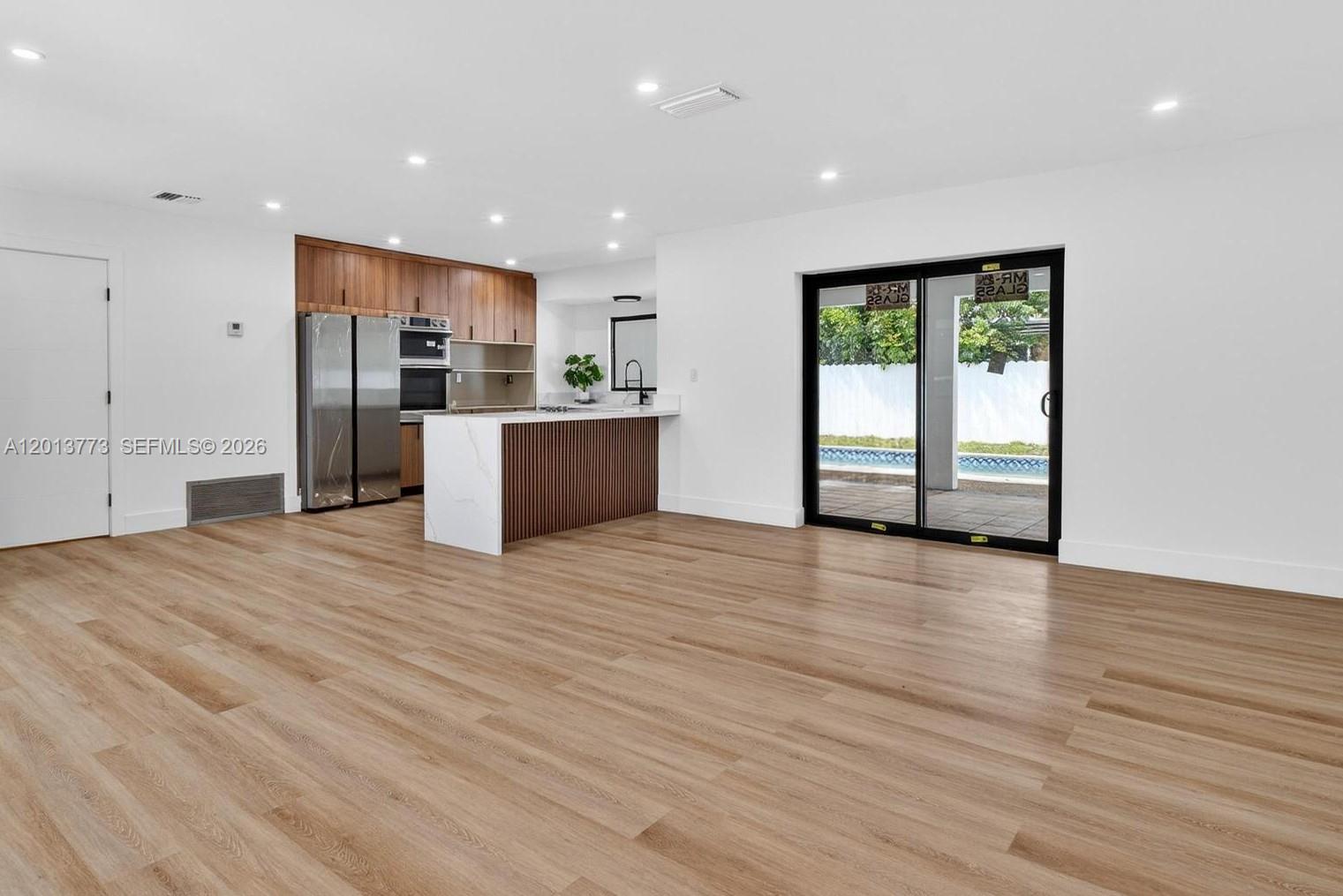Fully renovated 3/4 pool home in Miramar Park. Open layout with a beautiful kitchen: waterfall calacatta-style quartz, fluted walnut island, two-tone cabinets in walnut and matte grey, double wall ovens, cooktop, and full stainless appliance package. Three bathrooms with frameless walk-in showers and custom tile work, including a primary bath with a skylight. Plus a 4th full cabana bath that opens to the covered patio, great for pool days. Roof 2023, full impact windows and doors. Wide-plank wood-look LVP flooring throughout, recessed LED lighting, matte black hardware. Backyard is fully fenced with a resurfaced pool, new waterline tile, covered patio, and tropical landscaping. Minutes from I-95, the Turnpike, Hard Rock Stadium, schools, and shopping. Nothing left to do but move in.