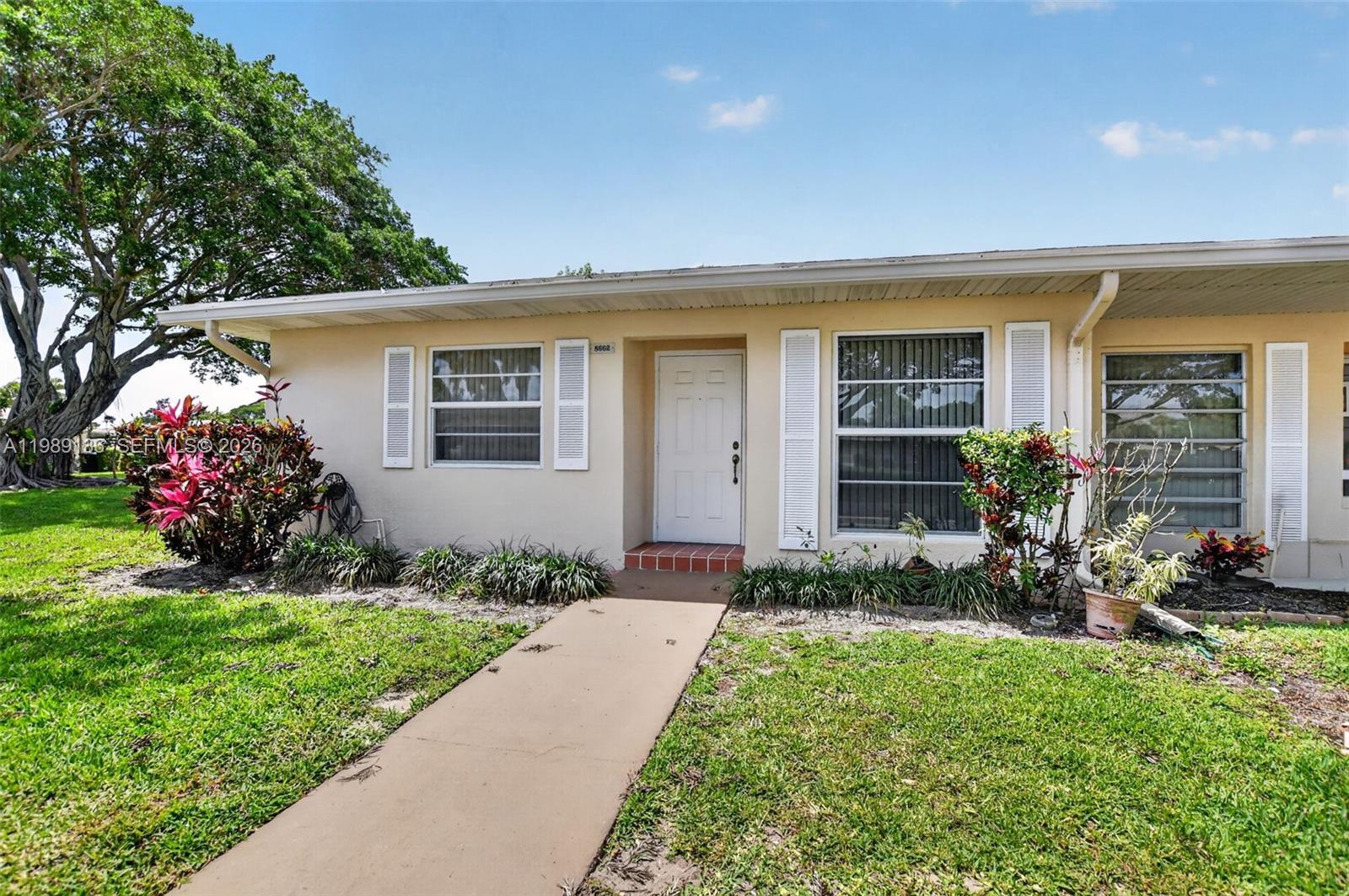 Experience the quintessential South Florida lifestyle in this beautifully updated corner villa, nestled within the gated 55+ community of Boca Lakes. This bright, inviting home features a spacious open-concept layout with modern wood-look tile flooring, Luxury Vinyl Plank & a fresh, neutral palette throughout. The kitchen offers crisp white cabinetry & a convenient laundry nook with a stacked washer/dryer. Both bathrooms have been tastefully upgraded & recent updates include a new 2025 water heater and ~4yr roof. Impact windows are featured throughout for your peace of mind, including dual-open rear windows for added versatility & airflow. The living & dining areas flow seamlessly to a private patio & expansive glass-enclosed sunroom, where floor-to-ceiling windows fill the space with natural light & showcase serene, landscaped views—ideal for everyday living & entertaining. Association fees include insurance, water, cable & internet w breezeline, offering exceptional value & ease of ownership. 2 parking spaces are located directly in front of the unit, with ample guest parking available. No Pets, must own 2 yrs before leasing. Boca Lakes offers amenities including a clubhouse, heated pool, tennis, pickleball, bocce & social activities. Ideally located close to I-95, Florida Turnpike, Town Center, Uptown Boca, Mizner Park & beaches, w easy access to PBI & FLL Airports. Perfect opportunity to enjoy low-maintenance living in one of Boca Raton’s most convenient 55+ communities.