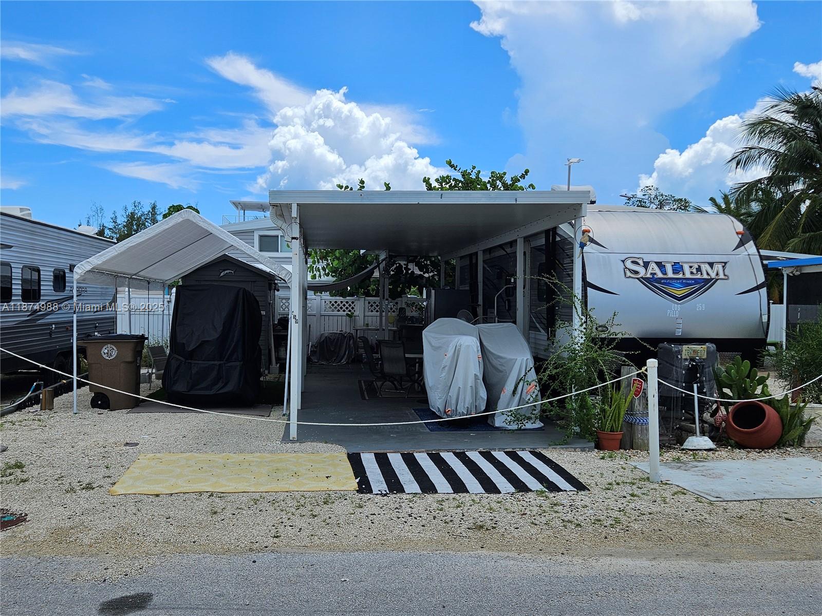 Priced to sell lot in Calusa.  2017 37 ft Salem Loft trailer with 2 bedrooms and 2 a/c. The lot has an insulated aluminum roof, over a cement slab, it includes a 10 x 8 aluminum storage shed.  Use it as a weekend get-a-way or rental income. Calusa is one of the few communities in the Florida Keys that allow short term rentals. Just an hour drive South from Miami and you are in paradise.  Calusa has many amenities like a marina/boat ramp, temporary dockage, boat storage, 24-hour security, tennis and basketball court, playground, onsite laundry, pool and recreational hall.  Additionally, the property is located close to several restaurants, shopping, entertainment, and health care.  Come see it and you will love it! Outside furniture included.  Owner financing available!! Call listing agent.