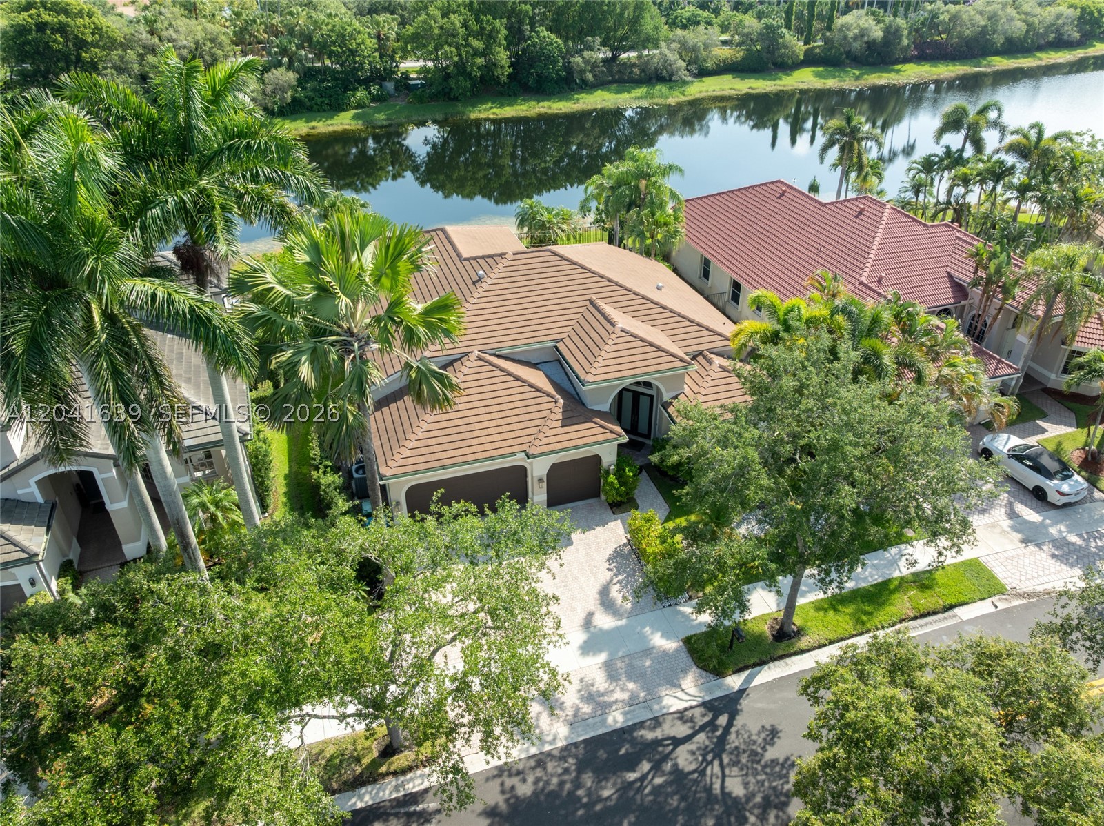Elegant, fully renovated waterfront-pool residence located in the heart of Weston – The Islands.   This exquisite estate offers 4 bedrooms plus a DEN and 3 bathrooms within a refined three-way split floor plan designed for privacy and comfort. This sophisticated home features soaring ceilings, abundant natural light, and private lake views throughout. Thoughtfully upgraded with a new roof (July 2022), exquisite polished travertine marble flooring, and high-end designer finishes to include high baseboards,  a custom-crafted chef's wood kitchen with premium stainless steel appliances and spa-inspired, fully renovated bathrooms.  Additional luxury features include plantation shutters, a comprehensive climate system with two-zone A/C and individual mini-split units in each room, and an air-conditioned three-car garage with sleek metallic epoxy flooring. The exterior is equally impressive with fresh paint, accordion shutters, and an impact-rated front entry. The extended marble patio frames the resort-style pool and tranquil waterfront setting, creating an exceptional outdoor living experience. Impeccably maintained and move-in ready.