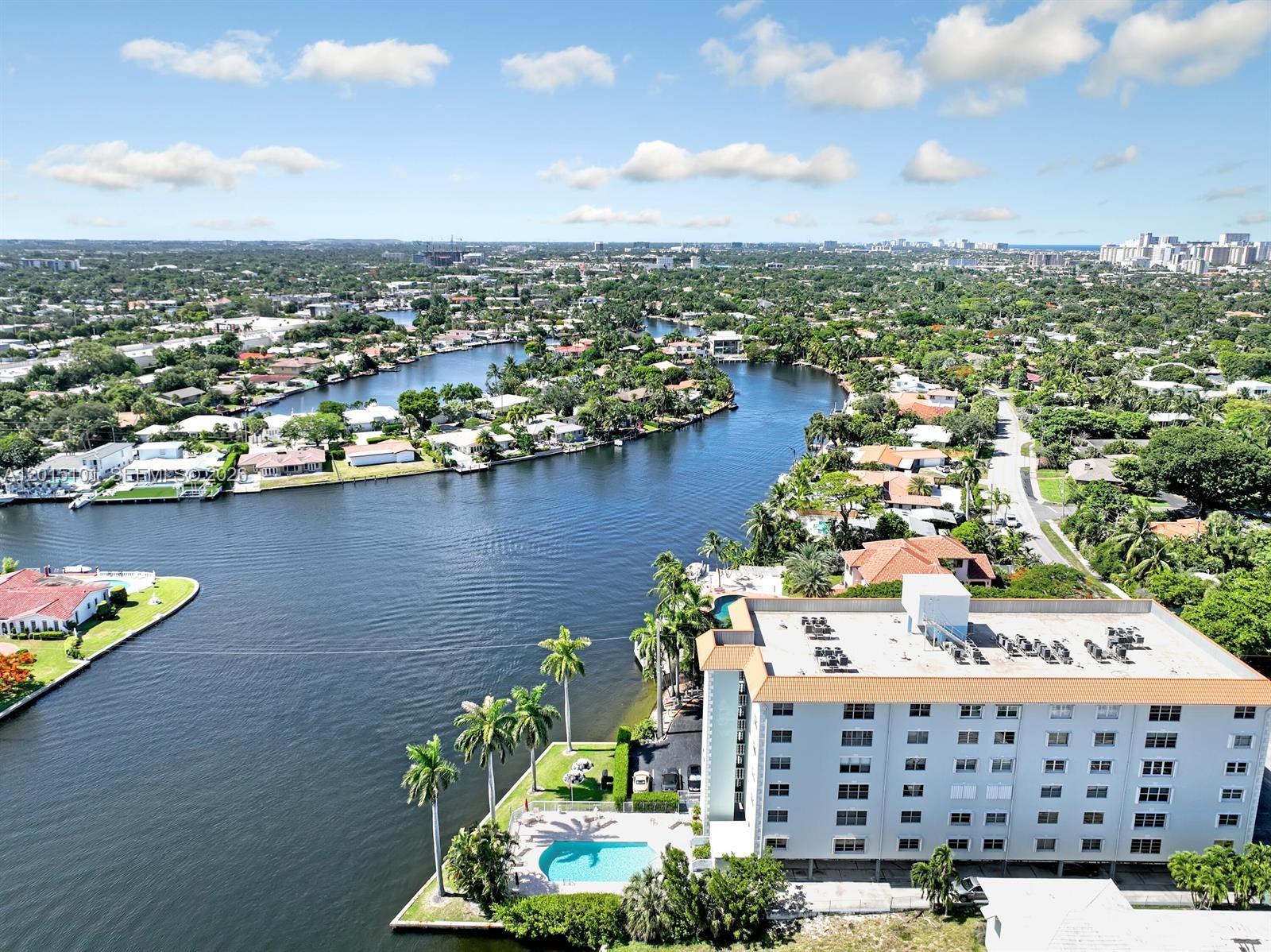 Motivated Seller just had a price improvement! Potential Owner Financing for the right situation, with 25% down @7.5% for 3-5 yrs.  Very Spacious (1525 sq. ft.) 2 bedroom with den- could be a THIRD bedroom- East Fort Lauderdale ON The Middle River in Coral Ridge. 'A' rated Bayview Elementary School is only blocks away. Corner unit updated with Bamboo flooring in the living areas and bedrooms, White Shaker cabinetry/ Granite countertops/ ALL Impact Windows/ Plantation Shutters. Main bathroom has dual vanities and combo shower/tub.  2nd bathroom is a "Jack and Jill" between the other two bedrooms.  Gorgeous views of the Middle River.  Location is convenient to downtown, shopping, dining, Ft. Laud. Beach, Holy Cross & Imperial Point Hospitals, and schools.  Parking is assigned under the building. Building and  Lobby are secure.  Beautifully maintained pool on the river.  Investors can rent immediately. Washer and Dryer are on the same floor. Priced under tax value for a quick sale. No Dogs per the condo association. A cat is ok.