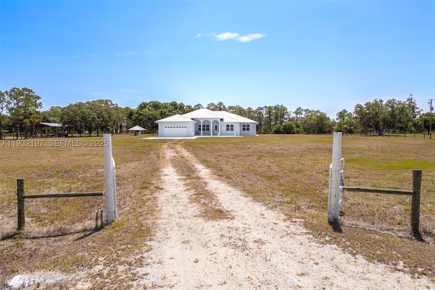Outstanding in its Field! You will find this Custom Built 4 bedroom, 3 bath home placed in the middle of 4.85 acres of QUIET! Located down a peaceful, dead end road you will find this well built home with a metal roof and completely fenced offering years of carefree living. Inside you will find and easy to love floorplan and very spacious rooms. A well designed kitchen is the heart of the home offering an abundance of quartz countertops, a small island worktable, a gas stove (there is an electric plug installed behind the stove if you want to change to electric) and breakfast bar. High 10, 12 and 13 foot ceilings and 8' doors throughout with abundant windows lend to plenty of natural lighting. Step outside onto the under truss back lanai and into a massive,14 gauge steel sturdy screened porch where possibilities are endless, party area, roller skating, this porch is amazing and is sure to please all. There is an abundance of outdoor electrical plugs, Nothing was overlooked with this solidly built home. A 45 ' container exist on the property and will convey. (One guest bathroom is completed, The master bathroom has room and plumbing for a tub and still needs vanities. The bathroom for the 2 bedrooms on the opposite side of the home still needs the vanities.) Seller is selling the home "AS Is". Finish the bathrooms to your own style and enjoy a Tranquil Country Lifestyle.