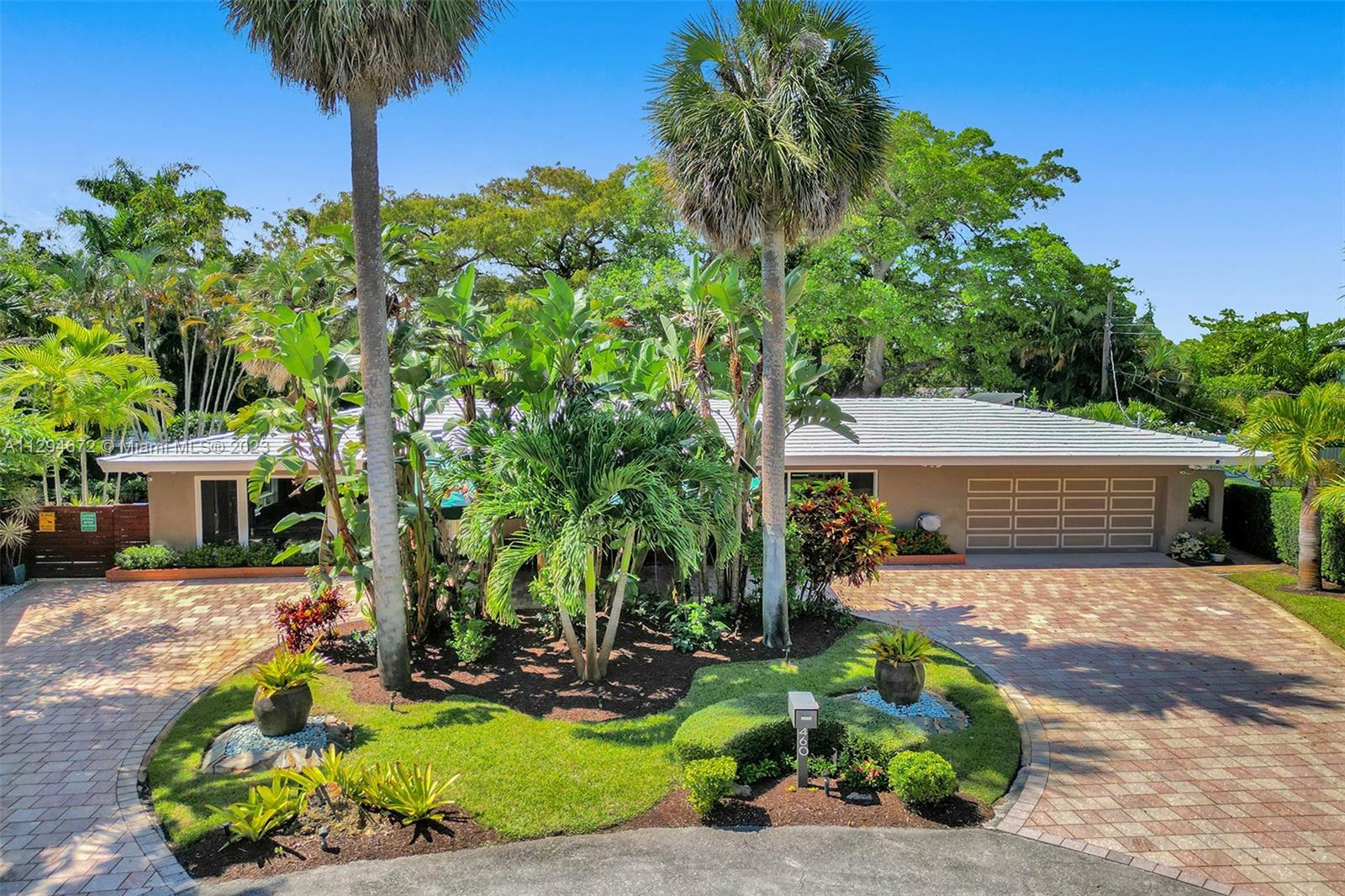A True Tropical Paradise on a double lot. Spacious custom home with tranquil water views and a floor plan that truly incorporates the best of both the indoor and outdoor living space. Thousands spent on Lush Tropical Landscaping that provides complete privacy. 700 sf. covered patio, Heated Salt Water pool & Spa, Gourmet kitchen w/ Miele appliances and custom cabinetry w/built in bar stools. Bamboo Hardwood flooring, updated baths and nice size rooms. Huge Master w/ large walk-in closet. 2 car garage w/built in cabinets.  Garage and patio have commercial grade epoxy floor w/ urethane clear coat. All Impact Windows & Doors. Nest Thermostats. All Wall Mounted TVs stay. An Entertainer's Dream. Can be sold Turnkey. A True Must See! Show and Sell!! See Broker Remarks