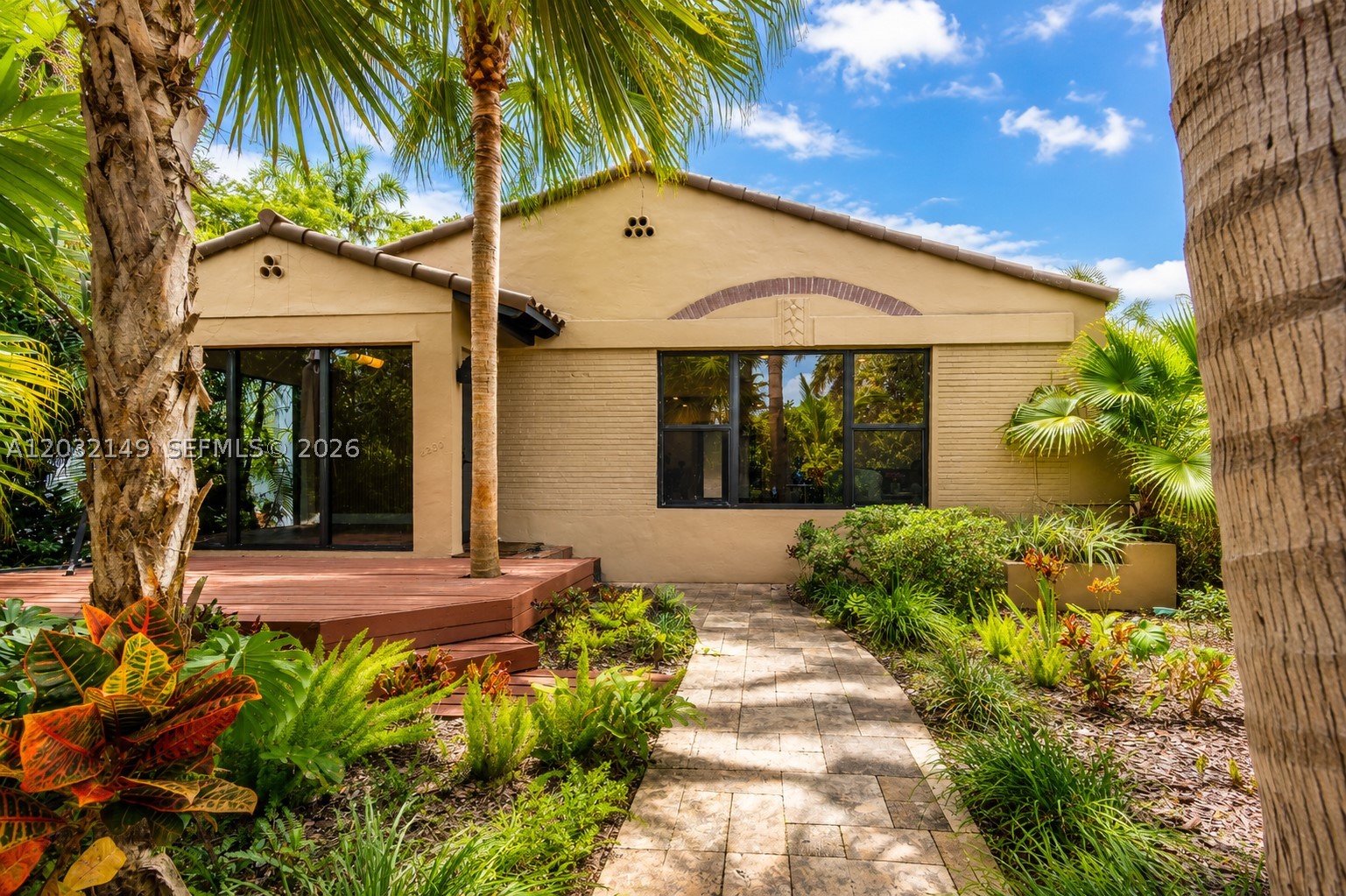 Charming Renovated Home. Royal Palm to Post Avenue. Renovated and offered furnished, this delightful 3-bedroom, 3-bath home, with wood floors throughout and impact doors and windows checks every box for effortless Florida living. Each bedroom features its own ensuite bath. The open island kitchen flows seamlessly into a generous dining and living area, an ideal layout for entertaining or relaxing in style. The entrance sun room with mosaic tile floors adds to the ample floor plan. Thoughtful finishes and an abundance of charm make every room feel warm and welcoming. The property enjoys a rare double-street lot, stretching from Royal Palm Av. to Post Avenue, offering exceptional privacy and flexibility. Out back, a partly wood-decked yard creates a perfect setting for outdoor dining, or lounging.  The front yard adds lovely curb appeal, completing the picture. A one-car garage with in-unit washer and dryer — accessed from Post Avenue — adds everyday convenience to this truly move-in ready gem.