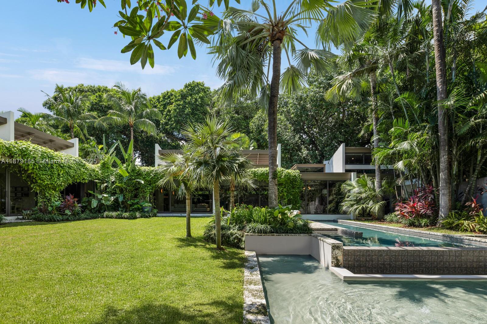 Stunning mid-century modern masterpiece awaits on exclusive Saint Gaudens Road! This 2023 ground-up rebuild by renowned Farache Bromberg Design Studio sits on a magnificent half-acre corner lot with lush landscaping by Raymond Jungles. Five bedrooms and five and a half bathrooms span over 5,000 square feet of sophisticated single-story living. High ceilings and beautiful skylights create an airy ambiance throughout. Top-tier finishes elevate every detail. The outdoor summer kitchen and cabana bath extend entertaining possibilities while an oversized swimming pool and massive backyard offer a serene setting for endless family enjoyment. The Property includes over 5,000 SF of additional land that is not included in tax rolls bringing the total lot size to approximately 25,000 SF.