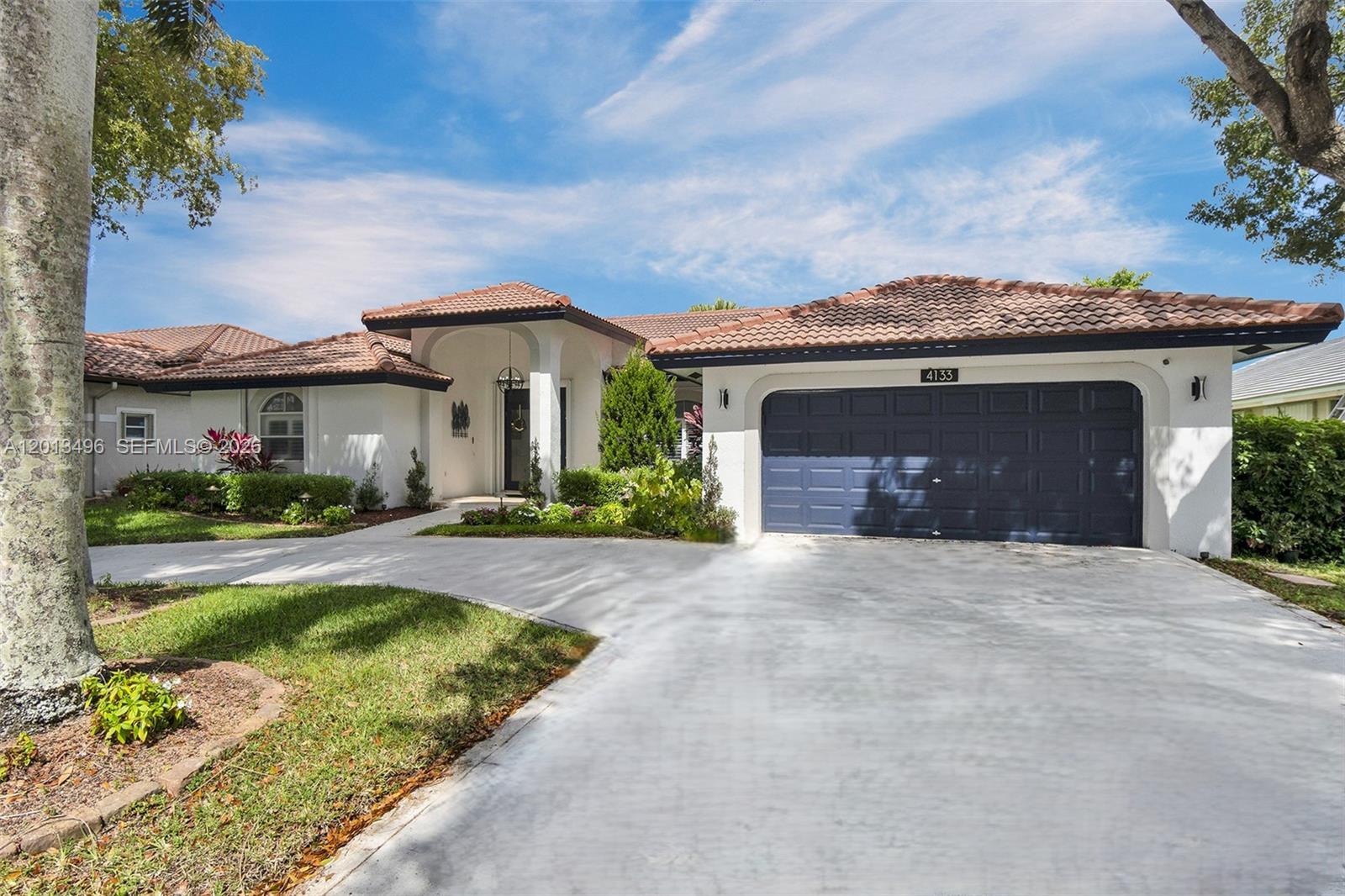Beautiful single-family home with 4 bedrooms, 3 bathrooms, and a 2-car garage inside a 24-hour security gated community. This residence offers vaulted ceilings, recessed lighting, and an open, light-filled layout. Updated kitchen with maple wood cabinetry and brand-new Samsung appliances. Spacious living areas flow seamlessly to a large backyard with a wood deck and screened patio featuring a hot tub—ideal for entertaining and relaxing. The primary suite includes two closets and a fully renovated bathroom with dual sinks, a frameless glass shower, a rain showerhead, and a soaking tub. Secondary bedrooms offer abundant natural light and include a Jack-and-Jill bathroom configuration. An additional full bathroom provides direct access to the backyard for added convenience. Additional features include full hurricane protection shutters and a 2024 A/C system.