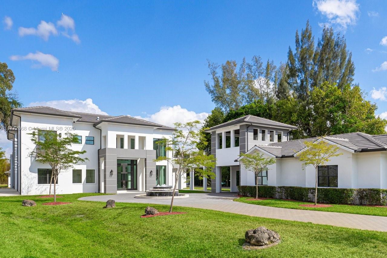 Magnificent Estate in the highly desirable Southwest Ranches. This 12,000+ SF contemporary masterpiece on 1.33 acres offers 7 en-suite bedrooms, 8.5 baths, a private detached guest house, theater room, plus an office, marble staircase, pool & spa, and interior commercial-grade elevator. At its heart, an indoor courtyard with a glass skylight showcases a stunning 20’+ Regal Palm. Beautiful chef’s kitchen boasts solid stone finishes, top-tier appliances, a butler's kitchen, and a walk-in pantry. Designed for entertaining, with a resort-style freeform pool featuring a beach entry and swim-up bar facing the fully equipped summer kitchen. A 4-car garage provides ample space, while gated entry and advanced security ensures privacy. A true blend of modern elegance and resort-style living.