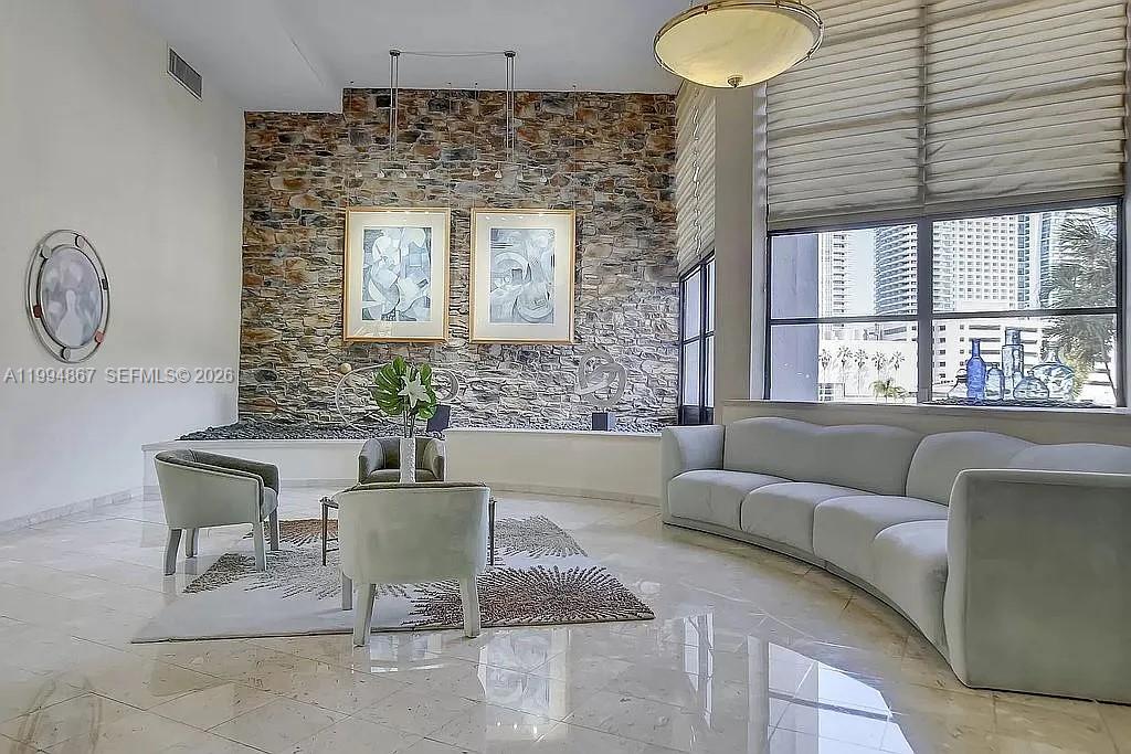 Waterfront living in the desirable Three Islands community east of US-1, just minutes from the beach. This furnished 1 bedroom + den condo with 1.5 baths offers direct Intracoastal views and a versatile den perfect for a guest room or home office. Bright and spacious with floor-to-ceiling windows, wood flooring, porcelain-tiled bathrooms and a large closet in the primary suite. HOA includes Wi-Fi. Enjoy sunsets from the private balcony overlooking the Intracoastal. Resort-style building amenities include 24h security, heated pool, fitness center, tennis courts, sauna, clubhouse, and BBQ area. Prime location minutes from the beach, Aventura Mall, Gulfstream Park, shopping, dining, and major highways. Excellent opportunity for a full-time residence, vacation home, or investment.