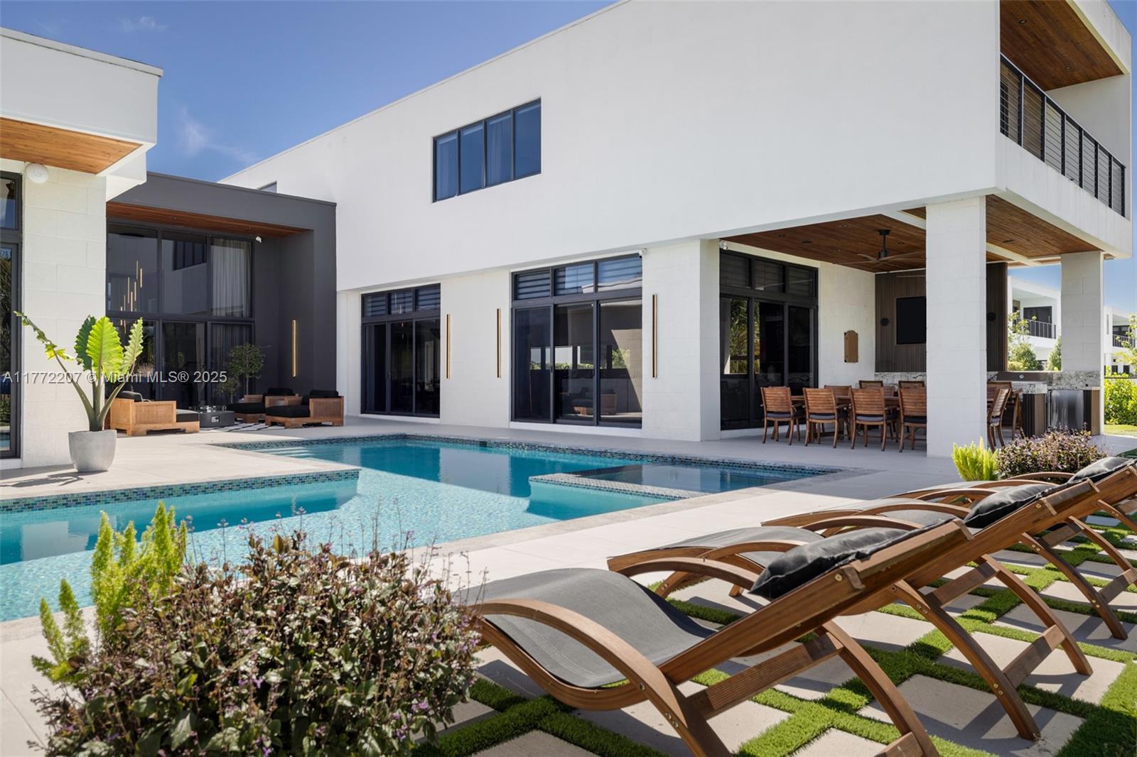 Welcome to this exquisite corner-lot residence, surrounded by water for exceptional privacy and tranquility. Step inside to 14-foot ceilings, a spacious living area and formal dining room with floor-to-ceiling windows framing the pool and garden. Designed by architect Oppenheim, this home includes a chef’s kitchen with Subzero/Wolf appliances, wine storage and two large pantries. The layout offers a media room, guest suite and maid’s quarters. Upstairs, a lounge leads to the primary suite and three en-suite bedrooms. The backyard is an entertainer's dream with a pool, outdoor shower and summer kitchen. Additional highlights include a four-car garage, guest parking & gated security in one of Weston’s premier communities close to top schools, parks, dining and shopping.