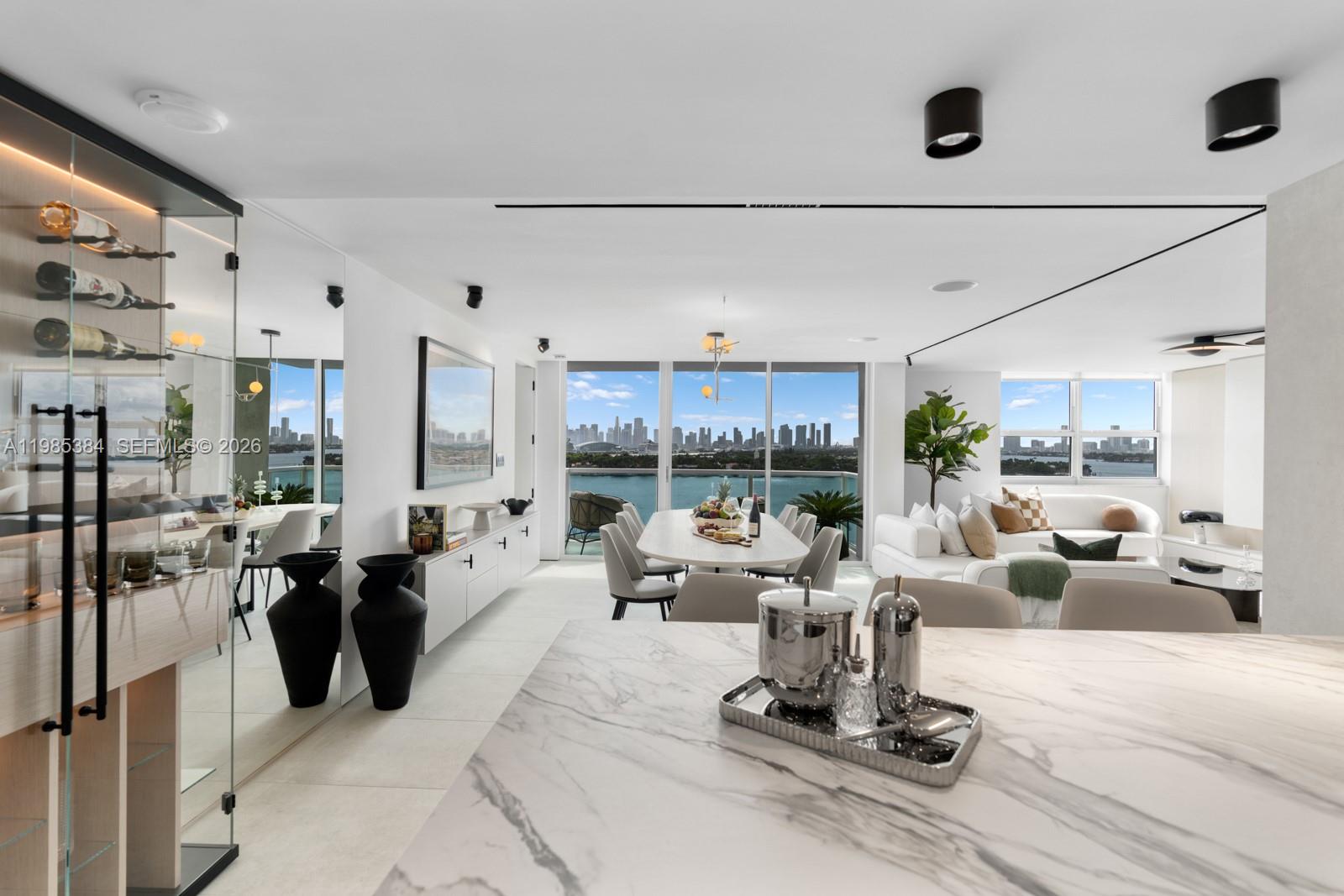 Step Inside With Me! This curated combo residence represents the finest interiors on West Avenue with perfect skyline views. The designer renovation by Sylvia Carrère takes the salon's millwork to another level. Ribbed, louvered, and back-lit, the white oak is showroom quality. Furnished by top European brands, the magazine-worthy appointments include Italian wood flooring, Caruso closets, and recessed lighting. The culinary experience features a wine cellar, custom buffet, and china cabinet. The primary suite shines with a specialty media wall, a contemporary bath setting, office nook and private terrace. With all living spaces and guestrooms facing the bay, the Western light is impeccable. A brand new park and close proximity to South of Fifth make this Floridian experience unmatched.