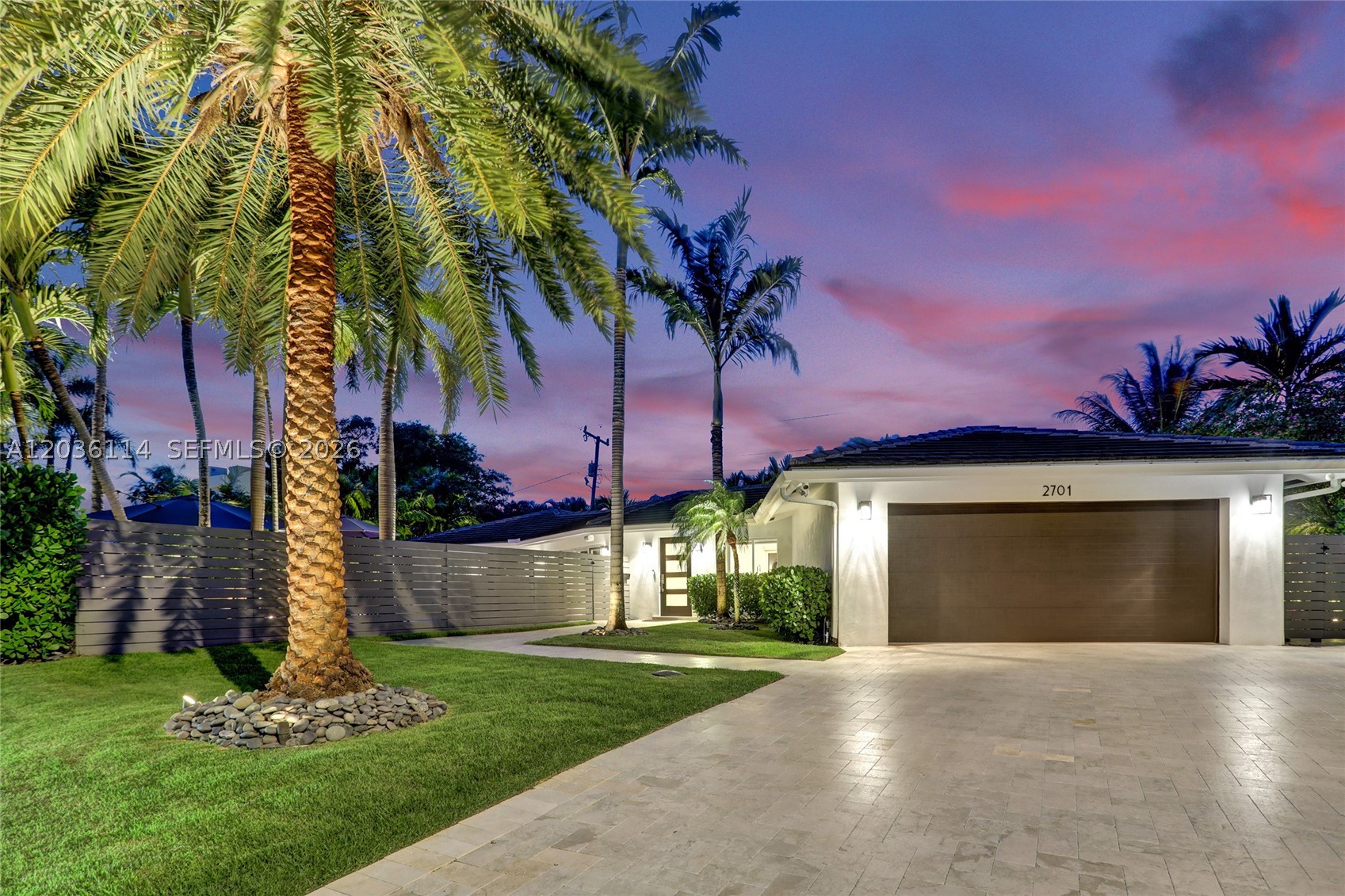 IF YOU LIKE THIS HOME DURING THE DAY, YOU’LL LOVE IT AT NIGHT! Welcome to a private, meticulously upgraded Coral Ridge retreat designed for effortless entertaining. Situated on a beautifully landscaped oversized lot, this 4BR/3BA gem features 2,851 total SF and over $200K in premium indoor/outdoor improvements. Experience ultimate Florida living with two distinct resort-style outdoor spaces: a spectacular 700+ SF covered StruXure Pergola X pavilion with motorized rain-shield louvers, and a second entertainment oasis boasting a heated saltwater pool with mood lighting, summer kitchen, putting green, and 3,000+ SF of travertine pavers. Inside, enjoy flawless bathroom and primary closet renovations by Wolfe Construction, alongside top-tier smart home tech (Sonos, Lutron, automated shades, Nest). Loaded with elite extras: 22kW Generac generator with 1,000g buried tank, Rinnai gas water heater, climate-controlled epoxy garage, and extensive landscape uplighting. Located in the coveted Bayview School District, close to the Beach, Galleria Mall, and Coral Ridge Country Club! SUN-DRENCHED BY DAY, SPECTACULAR BY NIGHT: WELCOME TO CORAL RIDGE’S ULTIMATE ENTERTAINER’S RETREAT