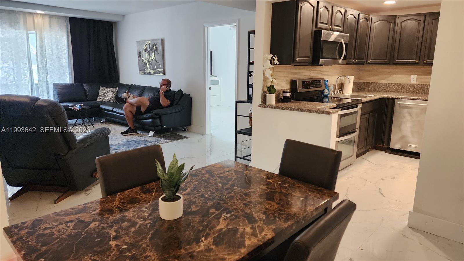 Beautifully updated 2-bedroom, 2-bathroom ground-floor condo in a desirable East Boca Raton location. This move-in ready unit features custom European-style media wall that extends throughout the living area and seamlessly continues into the screened patio, enhancing both design continuity and privacy.
Marble-look tile flooring runs throughout the entire unit, complemented by tastefully updated bathrooms with contemporary finishes. The spacious split-bedroom floor plan offers two generously sized bedrooms, each with walk-in closets, providing comfort and privacy along with abundant storage space.
Enjoy the convenience of an in-unit washer and dryer, as well as easy ground-floor access with close proximity to parking, making daily living and grocery access simple and practical. The patio offers direct exterior access and parked in front.
Community amenities include a pool, tennis courts, clubhouse, and barbecue area. The building also offers elevator access, guest parking, and bike storage.
Ideally located across from Florida Atlantic University, and close to downtown Boca Raton, beaches, shopping, dining, and major highways. School bus stop conveniently located near the building.
Unit may be rented immediately (subject to association rules). Special assessments have been paid.
