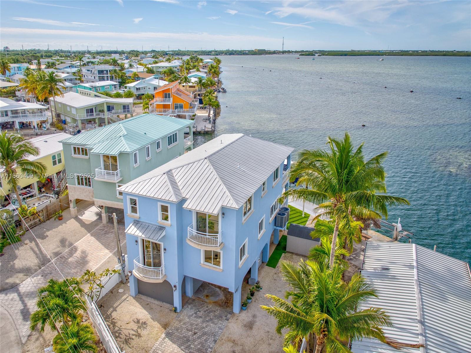 Waterfront luxury in the heart of the Florida Keys, where breathtaking sunsets paint the sky from your own backyard paradise. This stunning 3 bedroom, 2.5 bathroom home offers 2,638sq/ft of elegant living with marble floors flowing throughout. The chef's kitchen invites culinary adventures while impact windows frame panoramic water views. Step outside to your spacious backyard featuring a pergola,outdoor shower & fish cleaning station. Boating enthusiasts will appreciate the impressive 16,500 boat lift, making water access effortless. An elevator adds convenience between levels, while the open water location in prestigious Hammer Point provides endless possibilities for fishing, diving, and island exploration. Every sunset becomes a private show in this slice of Keys paradise. A MUST SEE.