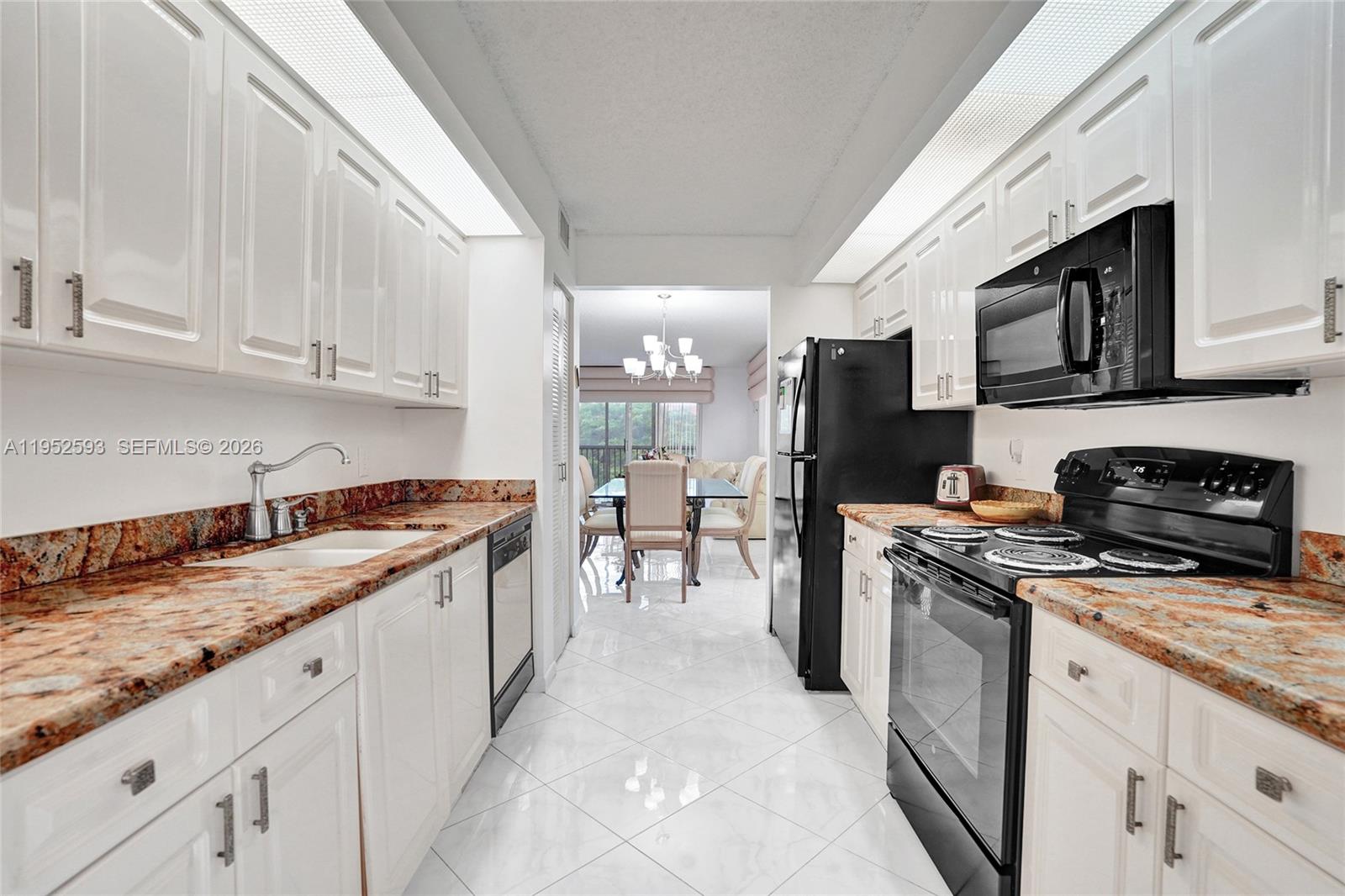 Beautifully updated 3rd-floor corner Magnolia in one of Century Village’s newer buildings. The community’s largest, most sought-after layout, with no building next door—flooded with natural light. New A/C installed March 2024, lightly used electric range, and tasteful finishes make this home move-in ready. Spacious galley kitchen with large breakfast nook, granite counters, and wood cabinetry. Primary suite with double-sink vanity; both bedrooms feature walk-in closets. Upholstered cornices and the corner kitchen display case are included; additional furnishings are available for a fee. Large light-toned, marble-look tile set on the diagonal unifies the entry, kitchen, and living areas. Enclosed porch with pool and garden views. Assigned parking directly in front, plus ample guest parking. Enjoy resort-style 55+ amenities: clubhouse, courtesy transportation, fitness centers, pools, tennis, movie theater, billiards, on-site pharmacy, café, golf, and more.